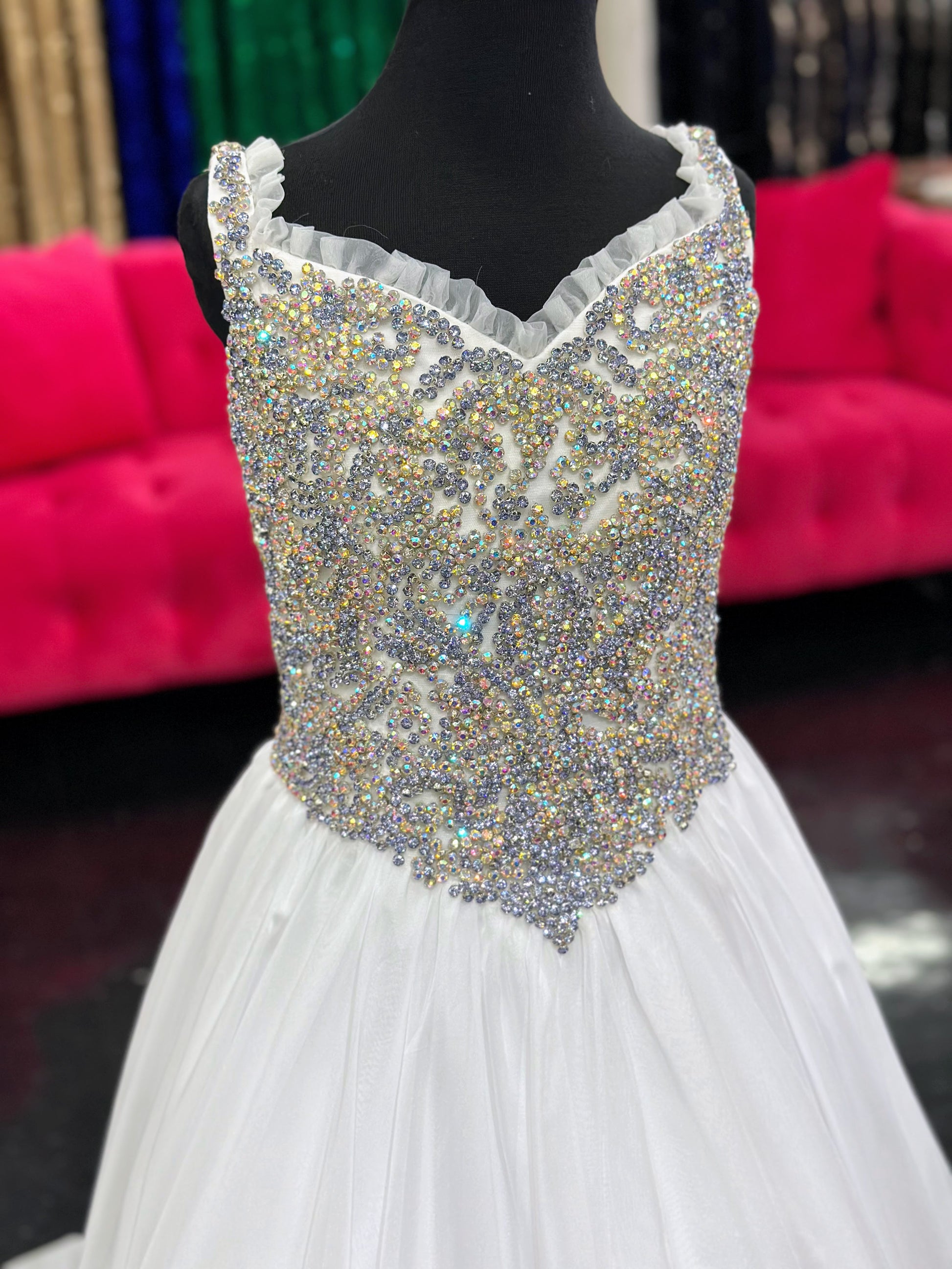 Experience the luxurious elegance of the Samantha Blake 1127 Pageant Dress. Made with soft, lightweight chiffon, this A-line ballgown will have your little girl feeling like a true princess. The crystal embellished bodice and ruffle trim neckline add a touch of sparkle and charm. Perfect for any pageant or special occasion.