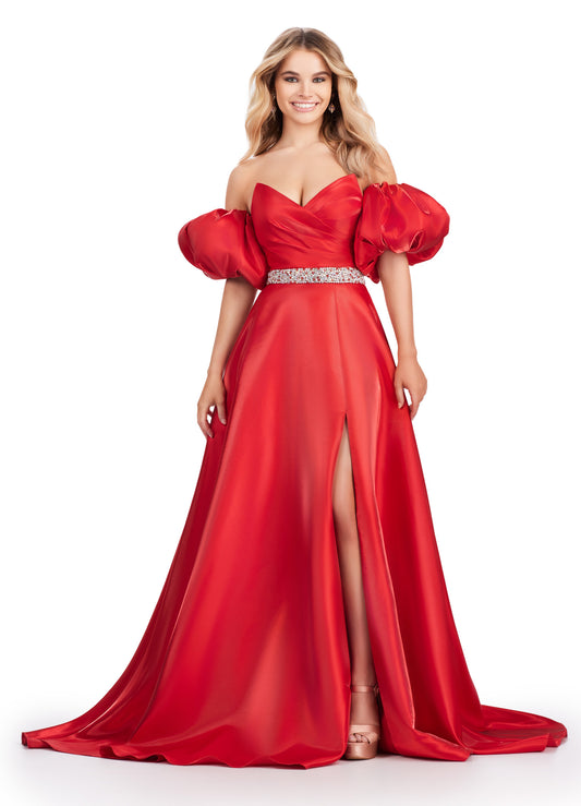 Elevate your formal look with the Ashley Lauren 11474 Long Prom Dress. This elegant strapless satin ball gown boasts a beaded belt, detachable puff sleeves, and a timeless pageant-style design. Perfect for making a statement at any event, this dress exudes sophistication and style. Be memorable in this strapless satin ball gown. This dress features a beaded belt detail, a left leg slit and detachable puff sleeves.