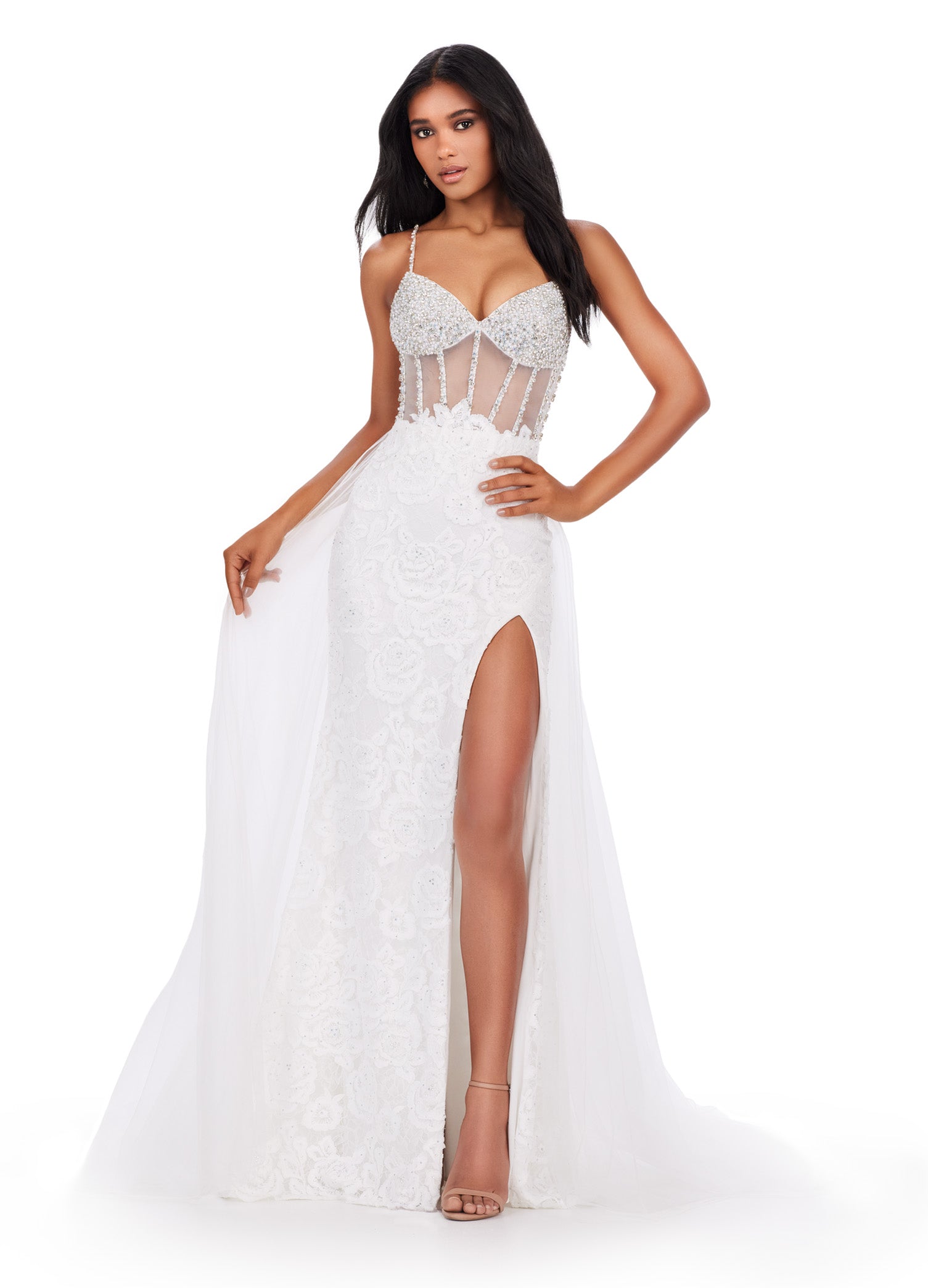 Be the star of the show in the Ashley Lauren 11517 Sheer Crystal Corset Lace Dress. Featuring a stunning corset lace bodice and sheer overskirt with a daring slit, this prom pageant gown is designed to make you stand out. Add a touch of glamour with crystal details and feel confident in this elegant and feminine dress. This romantic lace applique spaghetti strap gown features a beaded corset bustier. The look is completed a tulle overskirt.