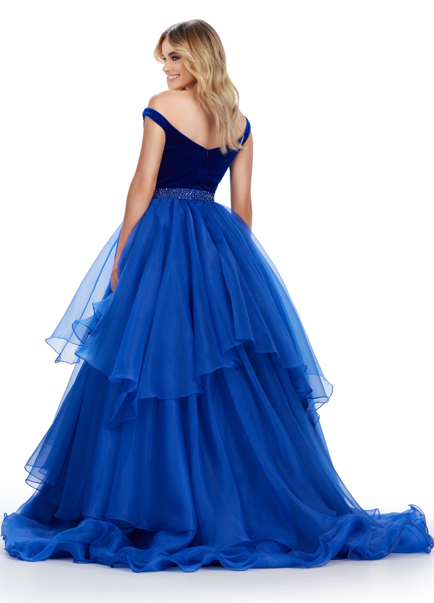 Stay on trend with this stunning Ashley Lauren prom dress. The off-shoulder design and organza ball gown create a classic silhouette, while the velvet bustier adds a touch of luxury. The beaded belt adds a flattering and stylish detail to this formal pageant gown. Elevate your prom look with this timeless and elegant dress. This striking off the shoulder ball gown features a velvet bodice with crystal trimmed waistline. The organza ruffle skirt completes the look.