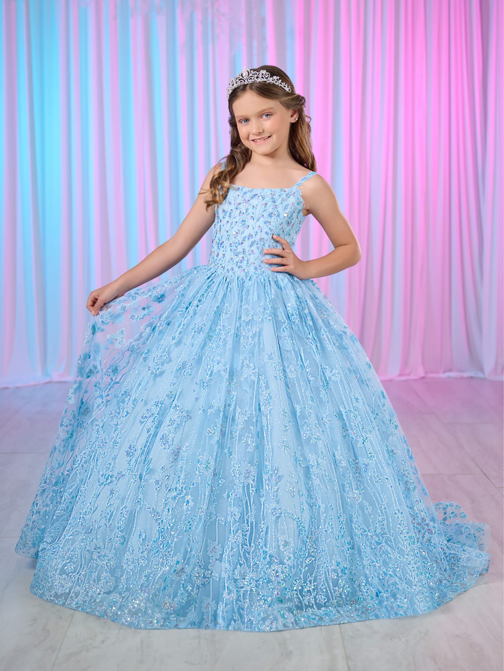 Get ready to dazzle in the Tiffany Princess 13755 Girls Glitter Pageant Dress. Featuring a long ball gown style with a sparkling sequin corset, this dress will make you shine like a star on stage. Be the center of attention and feel like royalty in this formal dress.