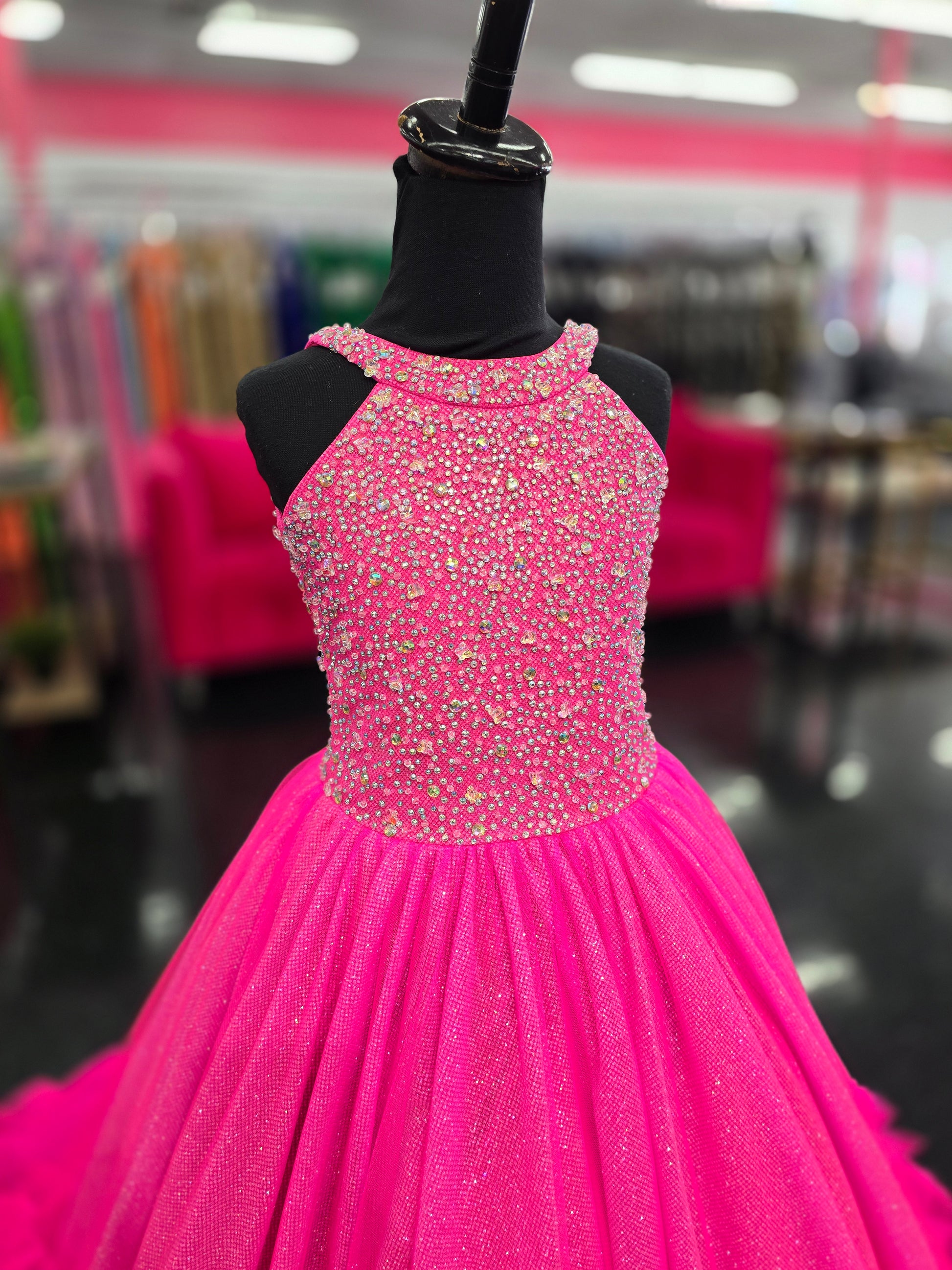 This Tiffany Princess pageant dress (style 13795) features a high neck, crystal embellishments, and a backless corset. The ruffle tulle skirt adds a touch of elegance, while the corset provides a secure fit. Perfect for any pageant girl looking to make a statement on stage.