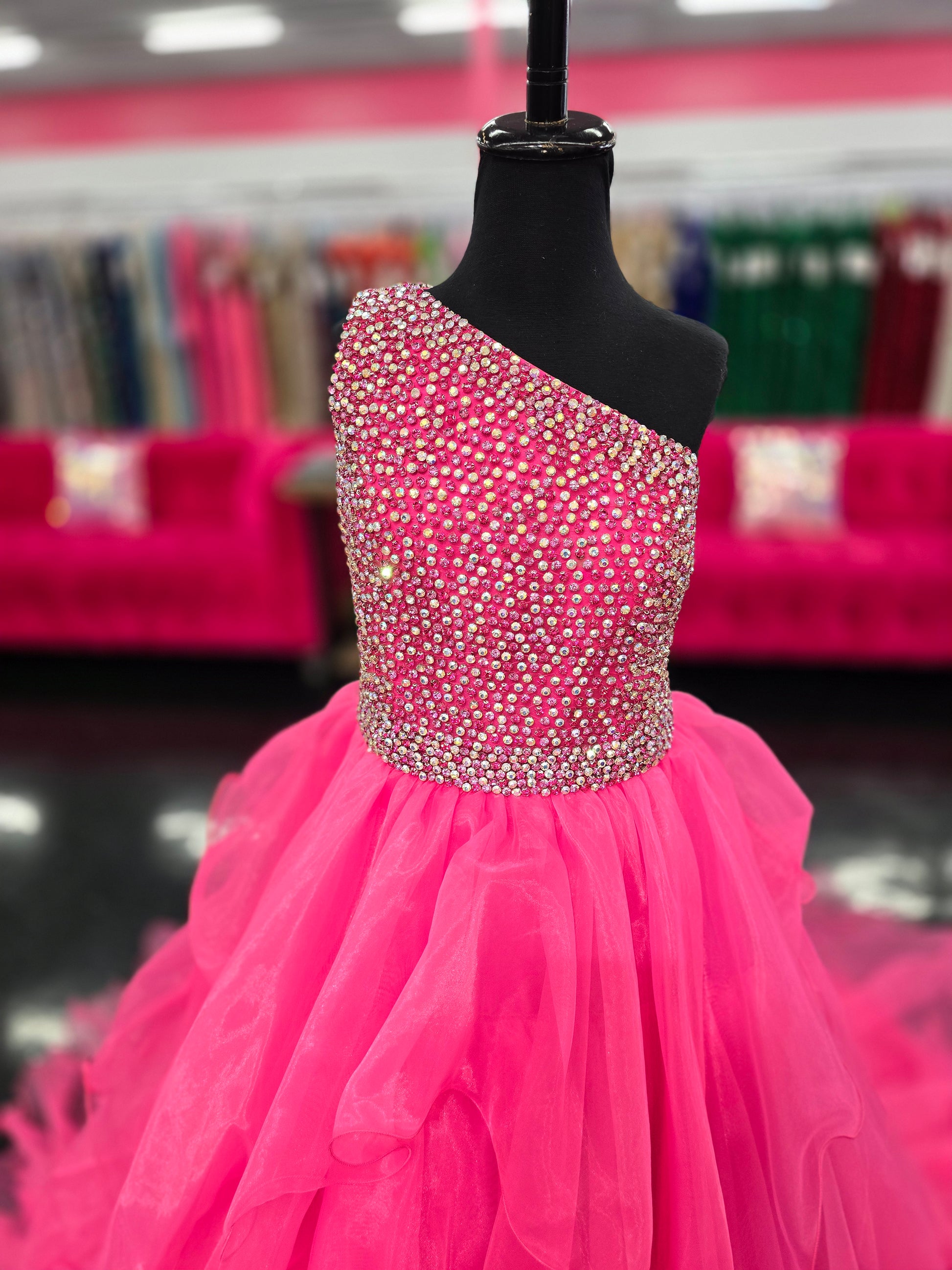 Introducing the Samantha Blake 1025 Girls Long Pageant Dress. Made with Chiffon Ruffle layers and a one shoulder design, this gown exudes elegance and sophistication. Perfect for formal events and pageants, your little girl will shine and feel like a princess in this stunning dress.&nbsp;