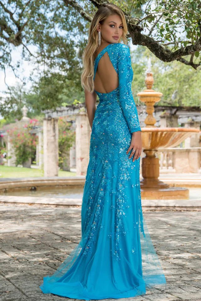 This stunning Ava Presley 28578 long prom dress features a one shoulder design with an intricate sequin pattern. The high slit and cape sleeve add a touch of elegance to this formal gown, making it perfect for any pageant or special occasion. Make a statement and stand out in style with Ava Presley.