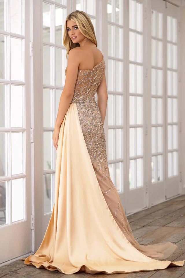 Expertly crafted for the ultimate prom or pageant look, the Ava Presley 28589 Long Prom Dress features a stunning one shoulder design, intricate beaded crystal detailing, and a sheer bodice for a touch of elegance. With a sleek side satin skirt and a high slit, this formal gown exudes sophistication and style.