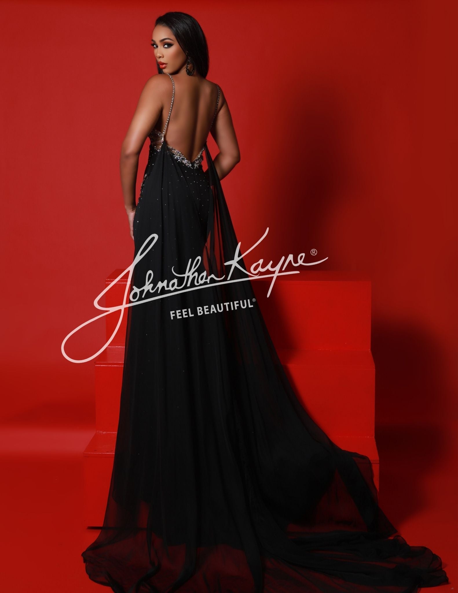 Become the center of attention in this Johnathan Kayne 2954 Long Crystal Slit Cape Pageant Dress. Featuring a V-neck and plunging neckline, this formal gown is embellished with shimmering crystals and features a dramatic slit cape.