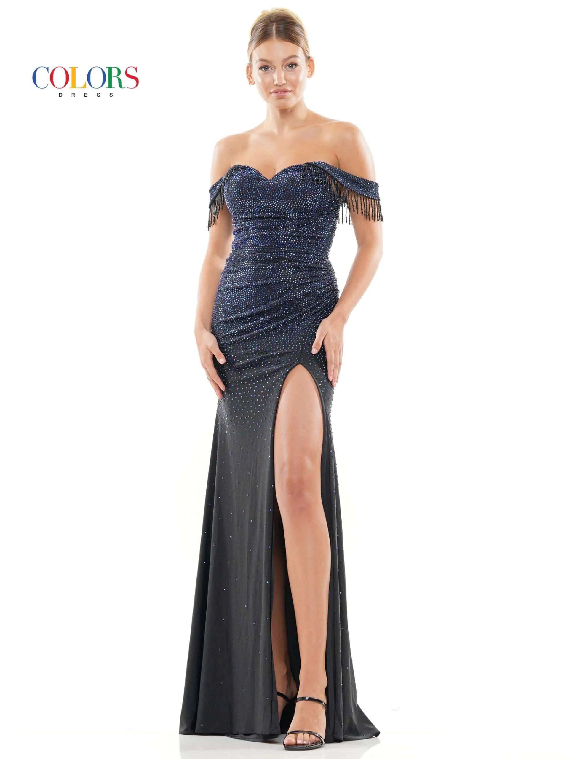 This glamorous formal dress from Colors Dress 3288 features off the shoulder fringe tassel sleeves, a crystal-studded bodice,  slit skirt, and a ruched waist detailing for a timeless and elegant look. Perfect for proms and special occasions.  Sizes: 0-22  Colors: Black, Deep Green, Turquoise