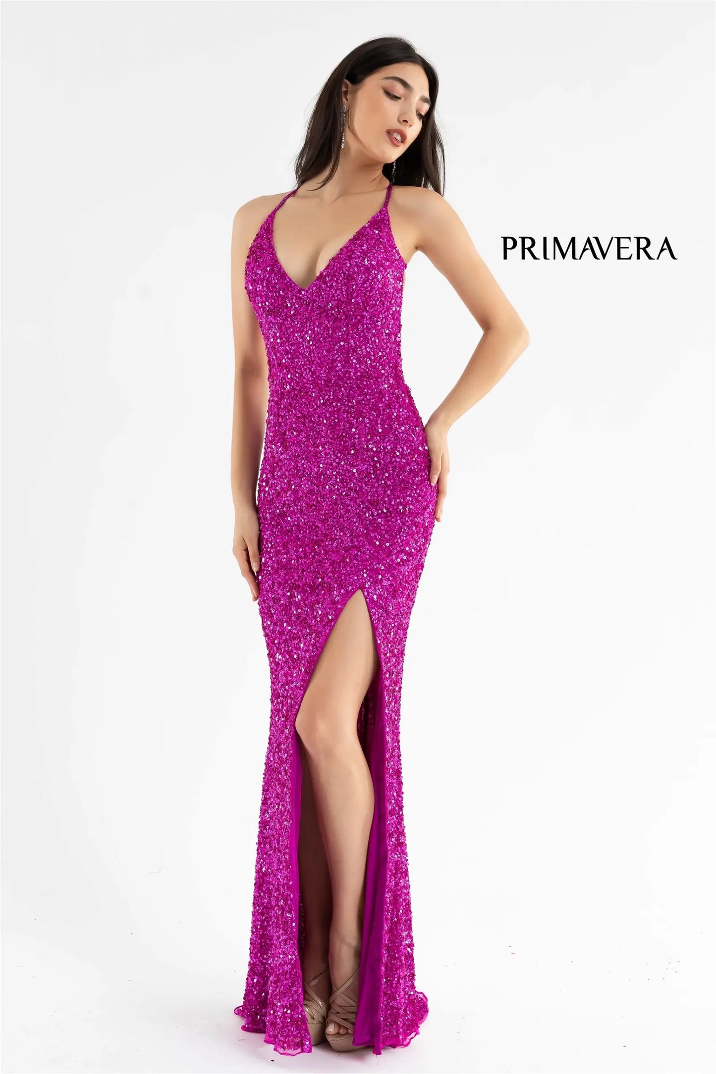 Primavera Couture 3291 Exclusive Prom Dresses.  This long prom dress is embellished throughout with shimmering sequins.  This impressive gown showcases a v neckline, thin beaded straps and crisscrossed straps in the open back. The long slim skirt has a sultry high side front slit. 