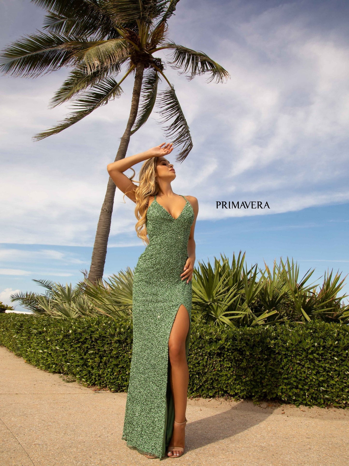 Primavera Couture 3291 Exclusive Prom Dresses.  This long prom dress is embellished throughout with shimmering sequins.  This impressive gown showcases a v neckline, thin beaded straps and crisscrossed straps in the open back. The long slim skirt has a sultry high side front slit. 