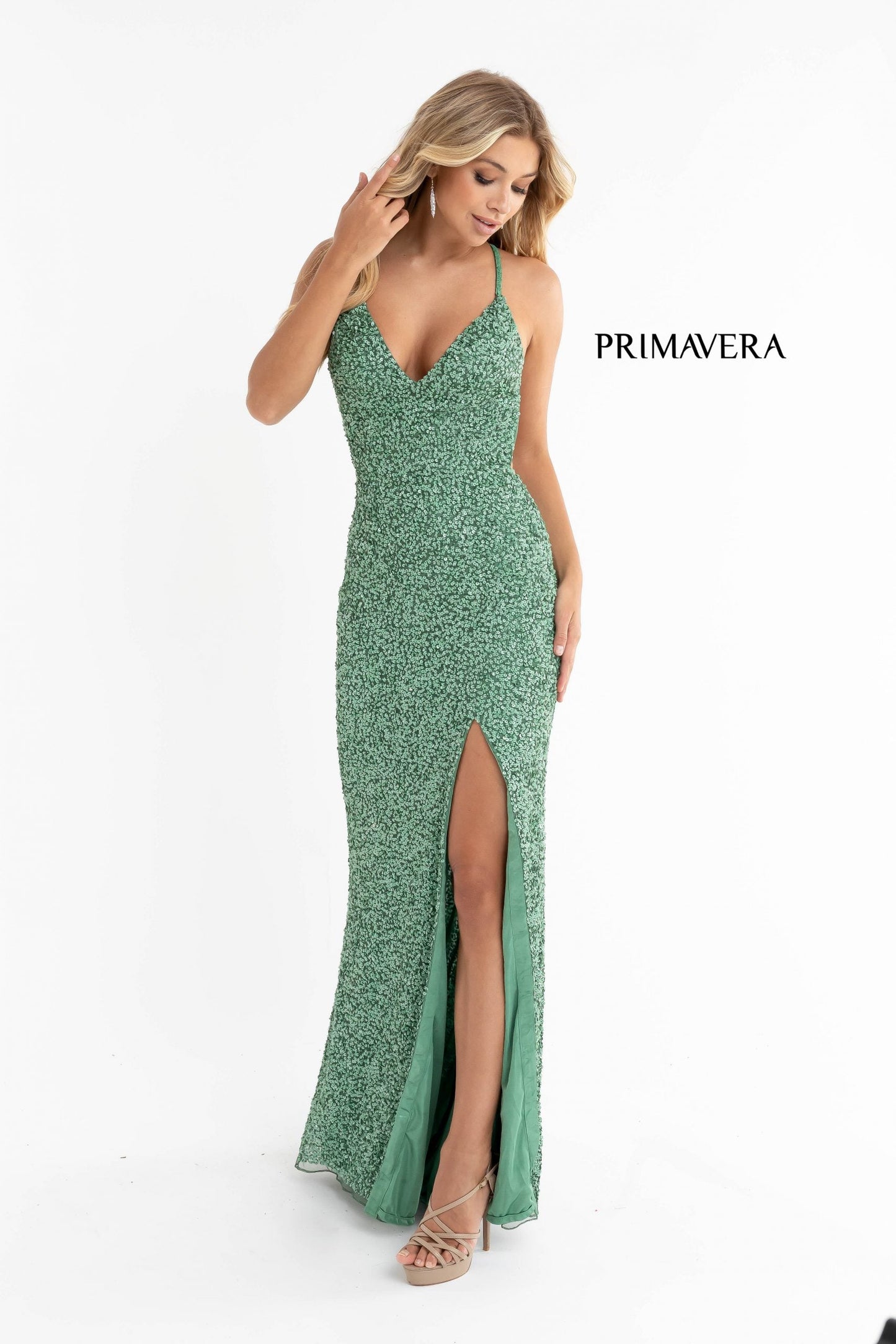 Primavera Couture 3291 Exclusive Prom Dresses.  This long prom dress is embellished throughout with shimmering sequins.  This impressive gown showcases a v neckline, thin beaded straps and crisscrossed straps in the open back. The long slim skirt has a sultry high side front slit. 