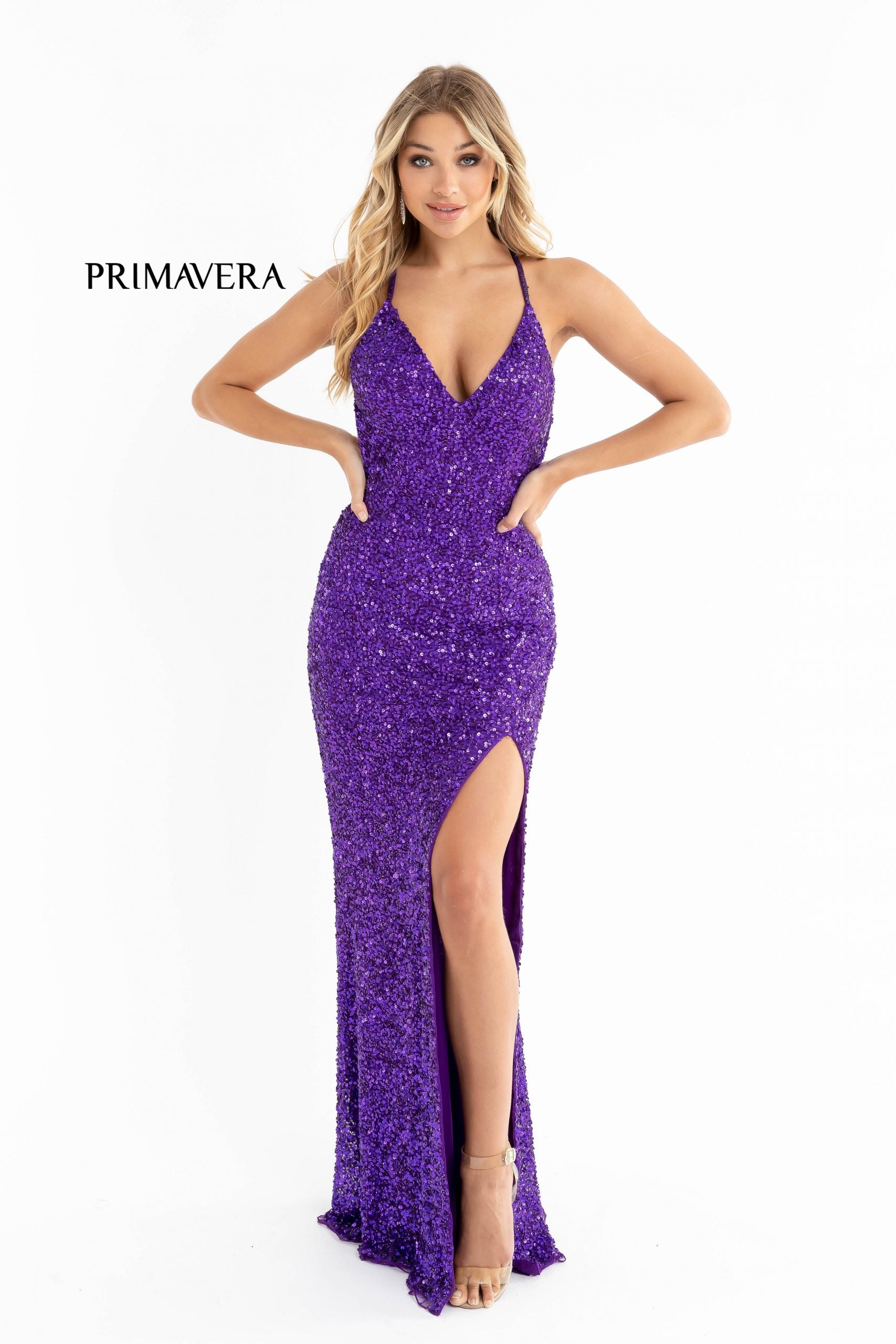 Primavera Couture 3291 Exclusive Prom Dresses.  This long prom dress is embellished throughout with shimmering sequins.  This impressive gown showcases a v neckline, thin beaded straps and crisscrossed straps in the open back. The long slim skirt has a sultry high side front slit. 