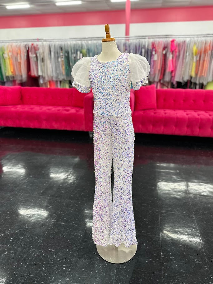 The Ava Presley 38044 jumpsuit blends sparkle and elegance with its sequin bodice and flowing detachable overskirt. With its short puff sleeves and glittering design, this outfit is perfect for making a unique statement at pageants or special events. The combination of a playful jumpsuit and a dramatic long skirt gives this ensemble a show-stopping appeal.

Sizes: 2-16