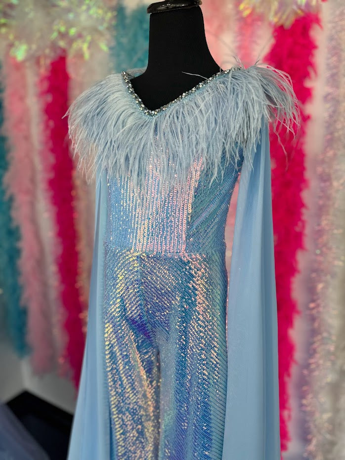 Ava Presley 38046 Long Sequin Jumpsuit is a delightfully fun fashion choice for girls. The detachable capes and feather bodice add playful panache for a statement-making look. The perfect pick for any occasion.  Sizes: 2-16  Colors: Red, Purple, White, Powder Blue