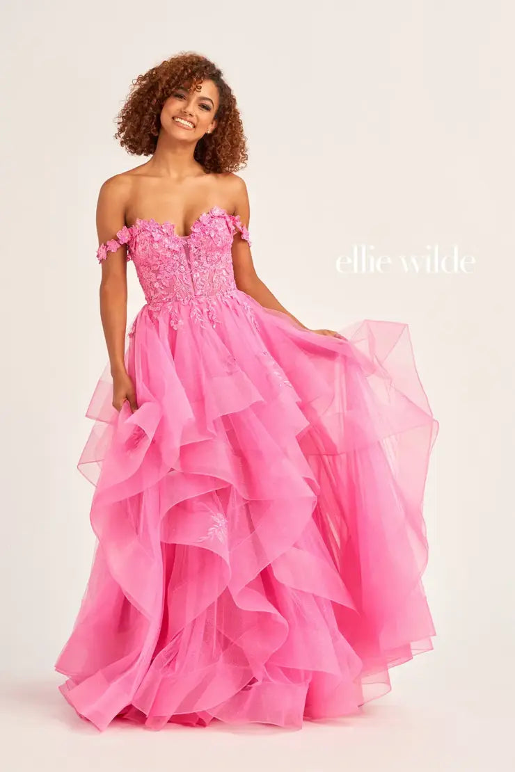 Make a statement in the Ellie Wilde EW35084 prom dress. Featuring an off-the-shoulder top, shimmer sequin lace and ruffle detail, the dress offers a timeless and sophisticated look perfect for the big night. Keep it classic in this classic formal gown.  Sizes: 00-24  Colors: EMERALD, ROYAL BLUE, TEAL, HOT PINK, BLUEBELL