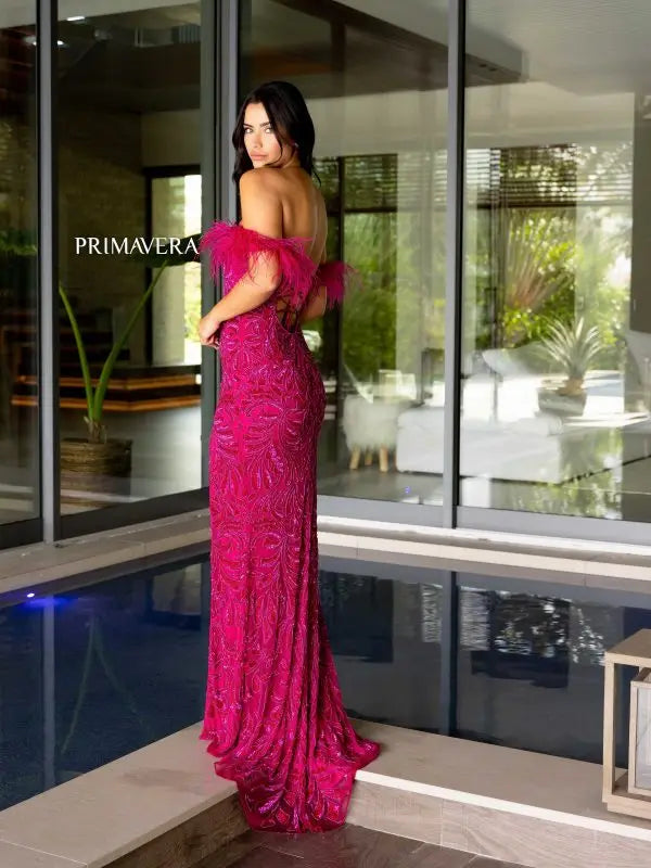 Elevate your style game with the Primavera Couture 4105 Long Prom Dress. Showcasing an off-shoulder design, this gown features a corset bodice adorned with feathers, sequins, and beads. Fitted and featuring a high slit, this formal pageant gown is perfect for making a statement at any event.