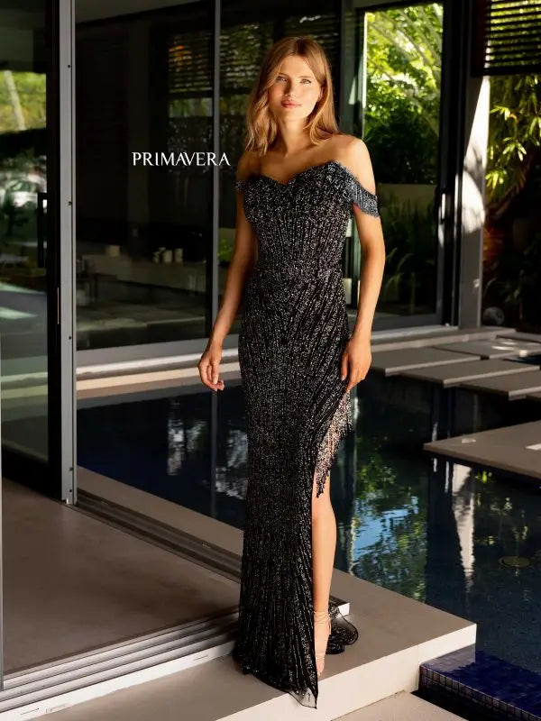 Step into the spotlight with the Primavera Couture 4127 Long Prom Dress. This stunning gown features a trendy off-shoulder neckline, a figure-flattering corset bodice, and intricate sequin and bead detailing. The fringe accents and high slit add a touch of glamour, making it the perfect choice for your next formal event or pageant.