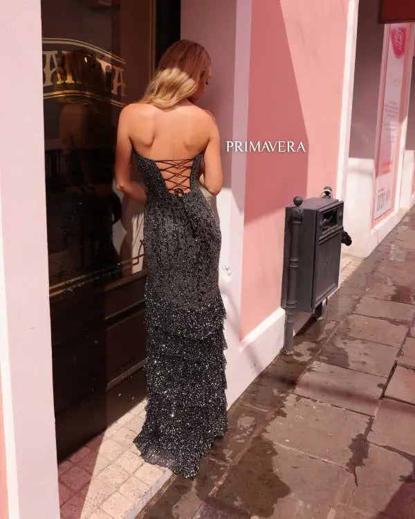 Elevate your formal attire with the stunning Primavera Couture 4128 long prom dress. This elegant gown features allover sequins, a fitted ruffle tiered design, and a strapless sweetheart neckline. Perfect for proms, pageants, or any special occasion. Make a statement in this truly exquisite and glamorous gown.