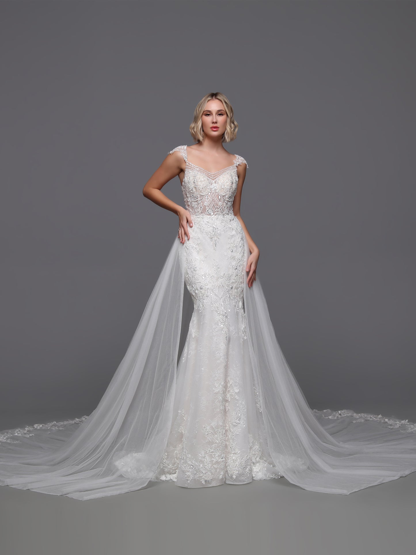 Experience the epitome of luxury with the Davinci Bridal 50875. This exquisite gown boasts a beaded sequin lace design, complemented by a detachable overskirt for added drama. The backless cut-out and beaded cap sleeves add a touch of sophistication to this elegant and exclusive wedding dress.