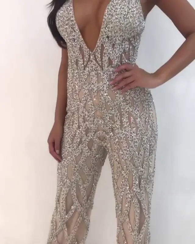 Silver Nude Plunging Neckline Beaded Contemporary Jumpsuit Jovani 61573  Sheer Illusion Rhinestone Crystal Embellishments Nude/Silver Deep V Neck Jumpsuit Pageants.  Silver and nude beaded contemporary jumpsuit with plunging neckline, low v-shaped back and sleeveless bodice, fully lined with wide waist belt and straight floor length leg.  Available colors:  Silver/Nude  Available sizes:  4