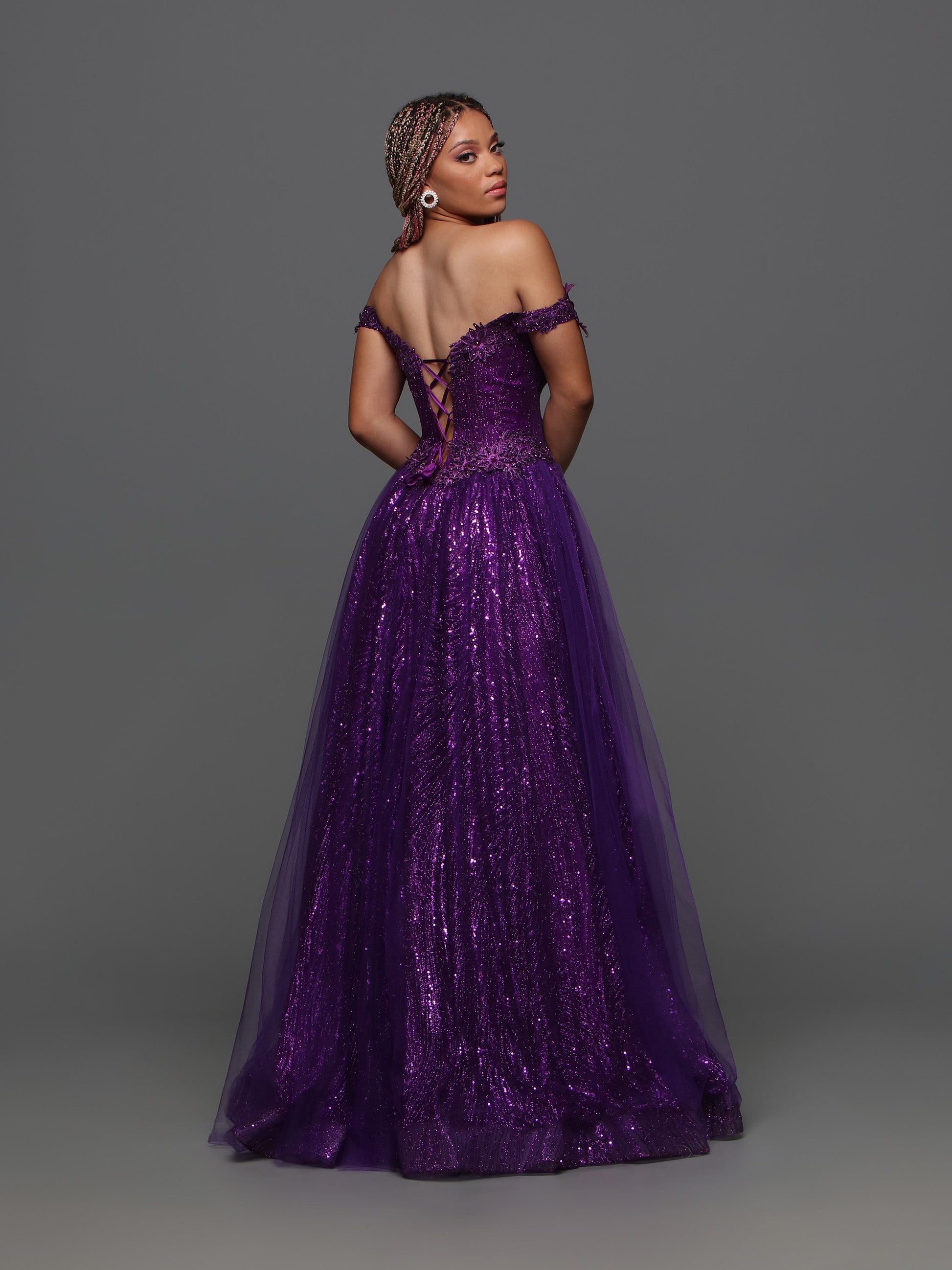 The Candice Wang 72405 A Line Glitter Tulle Lace Prom Dress features an off the shoulder design and a corset for a stunningly elegant look. The A-line shape, glitter tulle, and intricate lace details add a touch of glamour to this formal gown. Perfect for any special occasion.  Sizes: 0-20  Colors: Purple