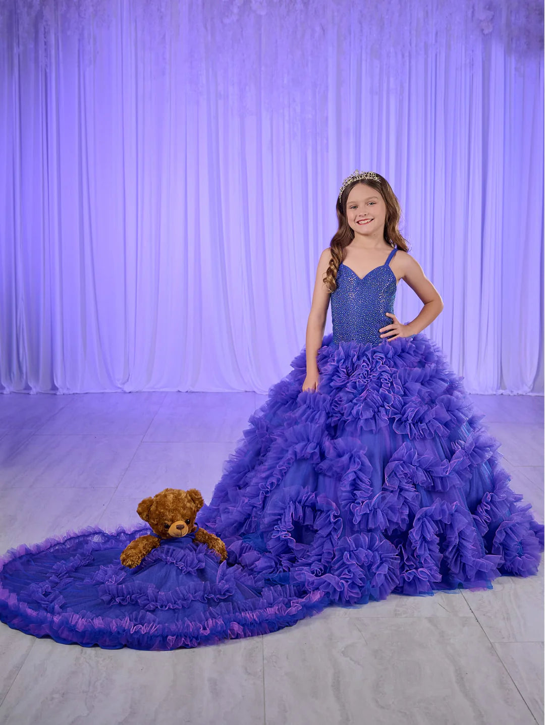 Rule the pageant stage with the Tiffany Princess 80023MQ Girls Ruffle Dress. This stunning ball gown features a crystal-embellished corset bodice and flowing ruffled skirt, perfect for making a grand entrance. The elegant design will have your little girl feeling like royalty, while the comfortable fit allows for graceful movement