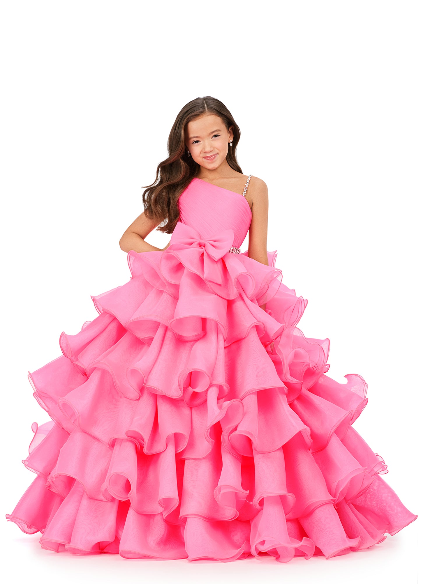 This Ashley Lauren Kids 8217 Long Ruffle Layer Girls Pageant Ballgown Bow Crystal Belt Gown is perfect for any special occasion! Elegantly crafted with an organza ball gown silhouette and one shoulder bustier, this dress also features beaded details along the waist line  and luxurious ruffles throughout the skirt. The waistband and shoulder strap are both beaded for added glam. One shoulder  Sizes: 4-16  Colors: Hot Pink, Aqua, Ivory