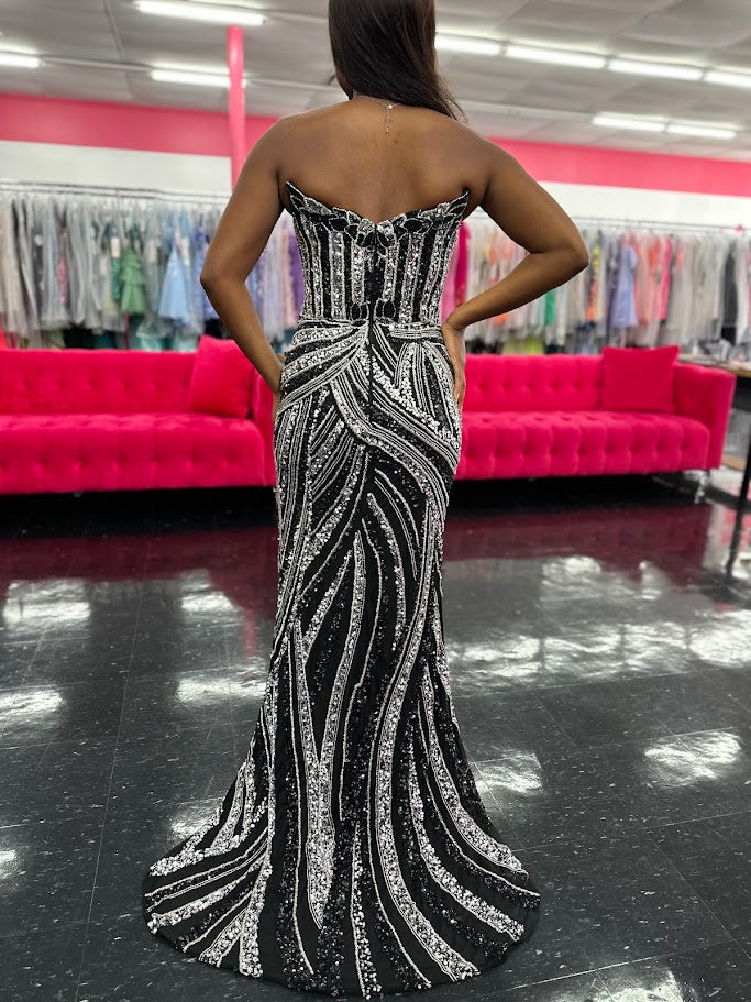 Ashley Lauren 11236 Long Fitted V Neck Slit Beaded Sequin Prom Dress Pageant Gown This strapless gown is sure to turn heads. The sweetheart neckline is complete with a modern floral sequin motif that continues down the bustier and skirt. The skirt is complete with a left leg slit.

COLORS: Black/Silver