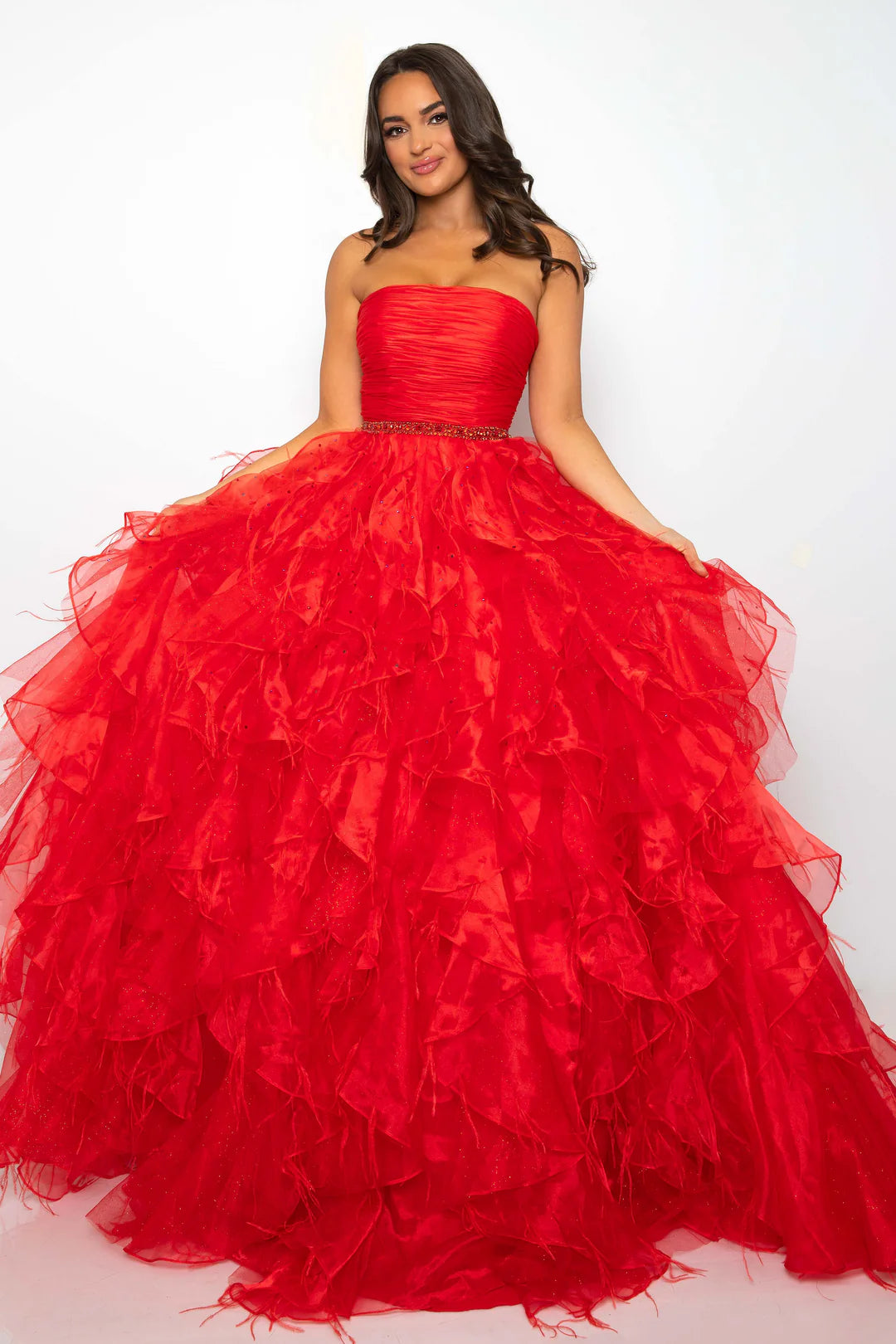 Elevate your formal attire with the Ava Presley 39555 Ballgown. This luxurious dress boasts a long feather ruffle and a strapless design, exuding elegance and style. Perfect for prom or pageants, this exclusive dress will make you feel like a true fashion icon. Float down the runway in this ethereal strapless ball gown, featuring a ruched bodice and cascading ruffle skirt that brings volume and drama. The cinched waist, adorned with a sparkling belt, adds a touch of glamour to this stunning look. Perfect fo