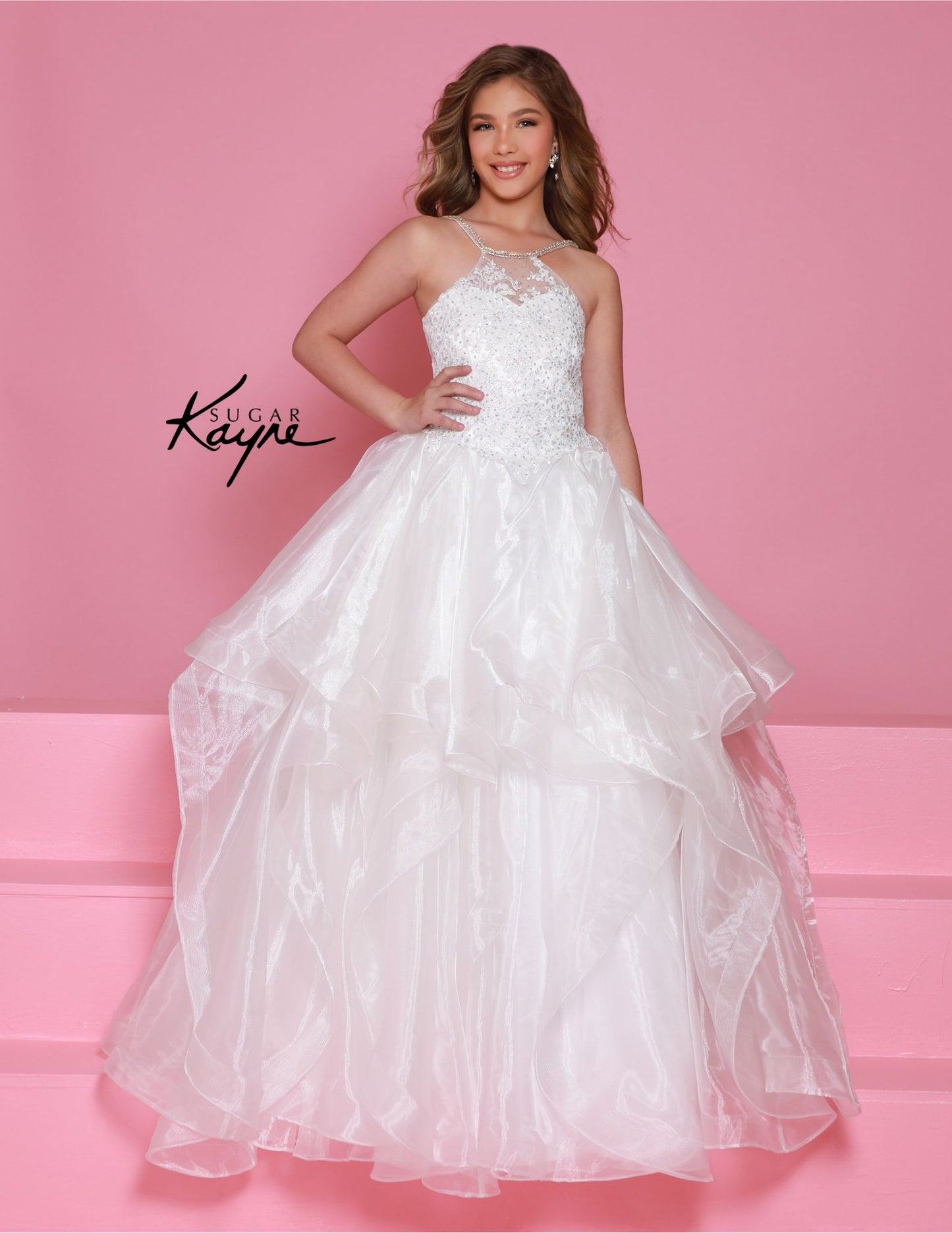 Introducing the elegant Sugar Kayne C375 Crystal Lace High Neck Girls Pageant Dress! With its intricate lace detailing and high neck design, this dress exudes sophistication and style. The ruffled A-line ballgown silhouette adds a touch of playfulness while maintaining a formal look. Perfect for any special occasion. Make a stunning impression at your next pageant with this exquisite halter-neck gown. Featuring a beaded bodice that adds a dazzling touch of sparkle, this gown offers both elegance and comfort