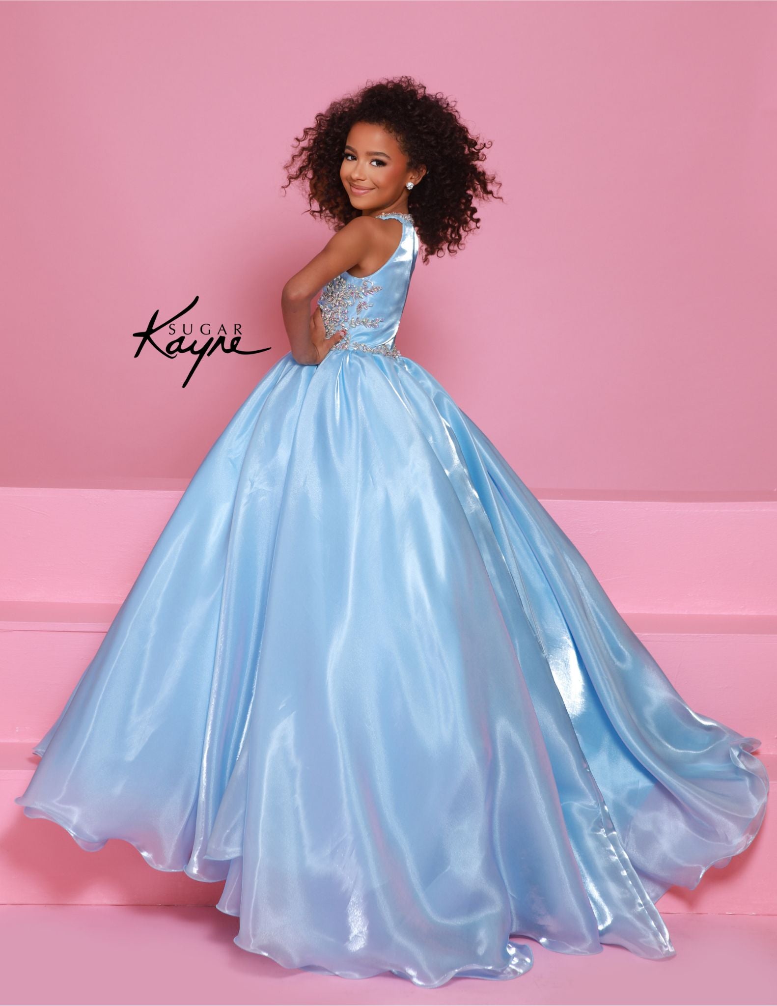 This stunning Sugar Kayne C379 pageant dress features a high neck and A-line design with shimmering beaded details. The elegant ballgown silhouette is perfect for any formal event, ensuring your little girl looks and feels like a princess. Make a statement with this beautiful and eye-catching dress. Step into the spotlight and embody the dazzling diva within! This mirror organza ballgown, with its elegant halter-style neckline, guarantees you’ll captivate the audience with both grace and style.&nbsp;

Sizes