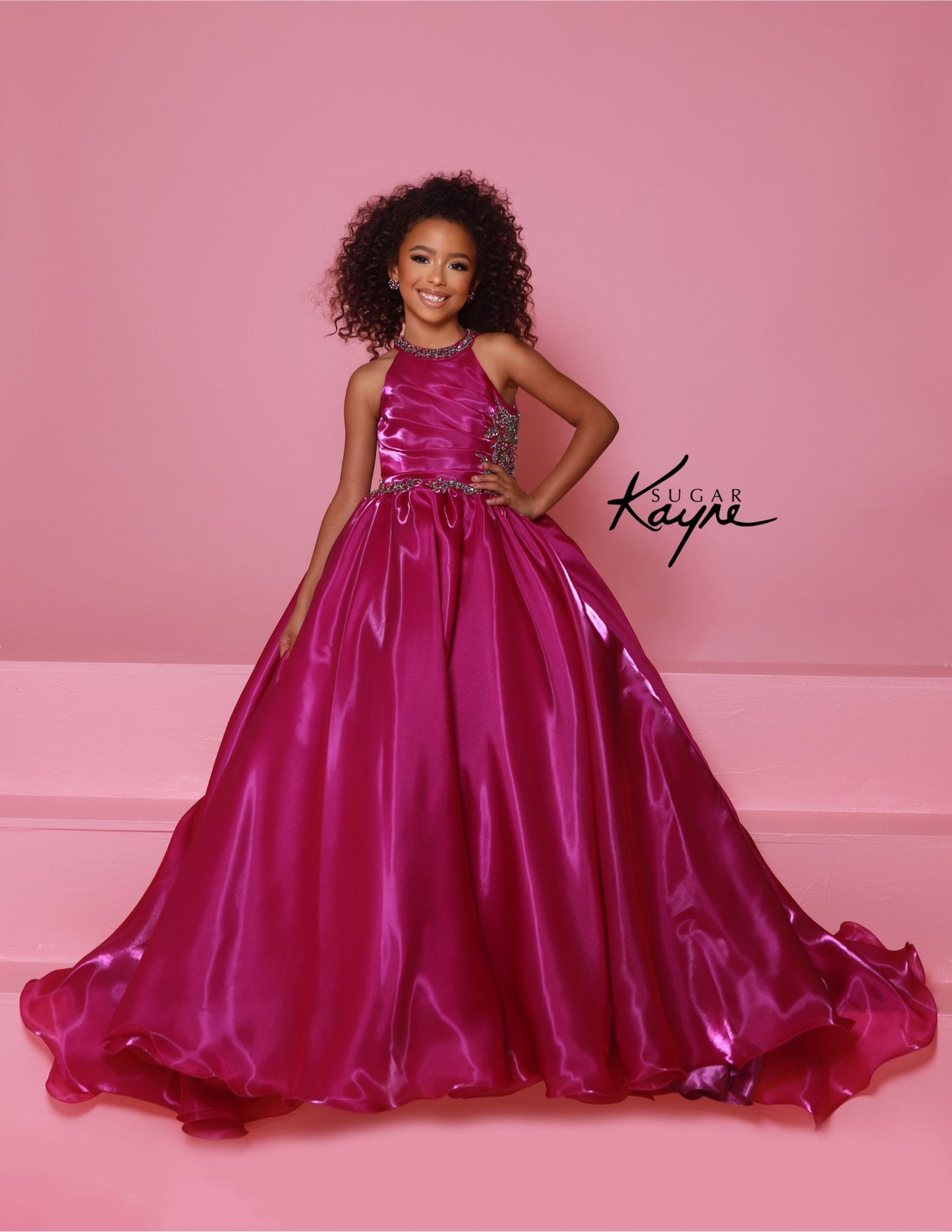 This stunning Sugar Kayne C379 pageant dress features a high neck and A-line design with shimmering beaded details. The elegant ballgown silhouette is perfect for any formal event, ensuring your little girl looks and feels like a princess. Make a statement with this beautiful and eye-catching dress. Step into the spotlight and embody the dazzling diva within! This mirror organza ballgown, with its elegant halter-style neckline, guarantees you’ll captivate the audience with both grace and style.&nbsp;

Sizes