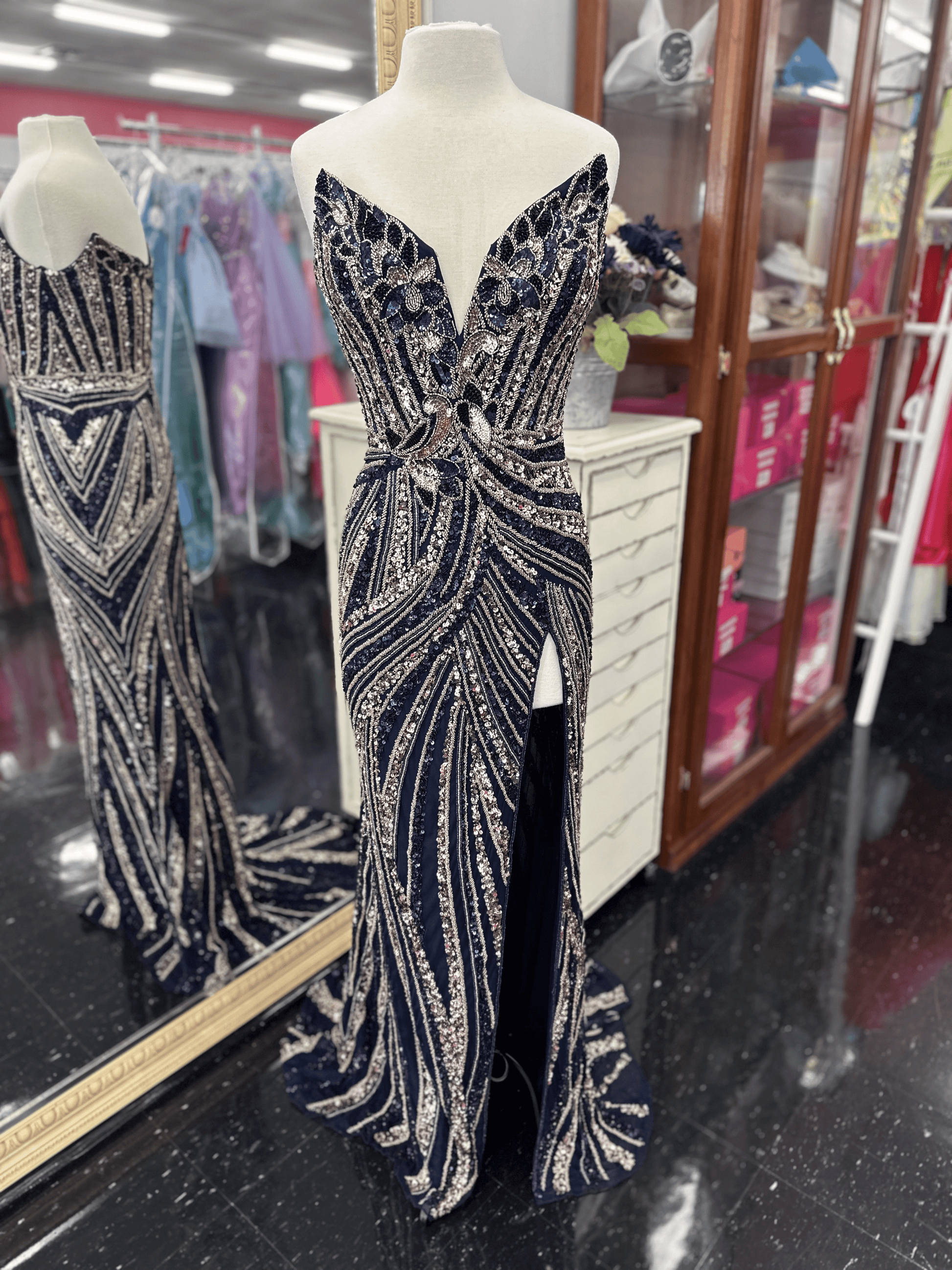 Ashley Lauren 11236 Long Fitted V Neck Slit Beaded Sequin Prom Dress Pageant Gown This strapless gown is sure to turn heads. The sweetheart neckline is complete with a modern floral sequin motif that continues down the bustier and skirt. The skirt is complete with a left leg slit.