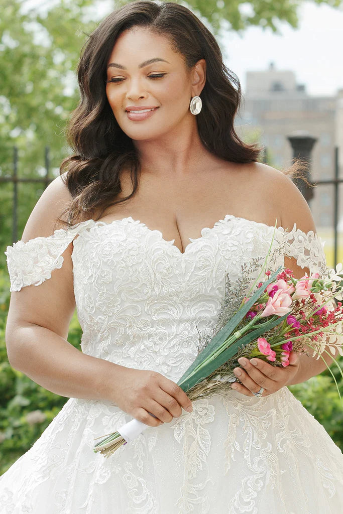 Michelle Bridal For Sydney's Closet MB2310 Soft Bridal Tulle Over Embossed Tulle Floral Pattern Embroidered Lace Appliques Clear Sequins Off The Shoulder Lace Straps  Plus Size "Denali" Bridal Gown. Featuring beautiful lace appliques, clear sequins, and off-the-shoulder straps, the Michelle Bridal For Sydney's Closet MB2310 plus-size wedding dress makes an eye-catching statement. Crafted from embroidered tulle and soft bridal tulle over embossed tulle,