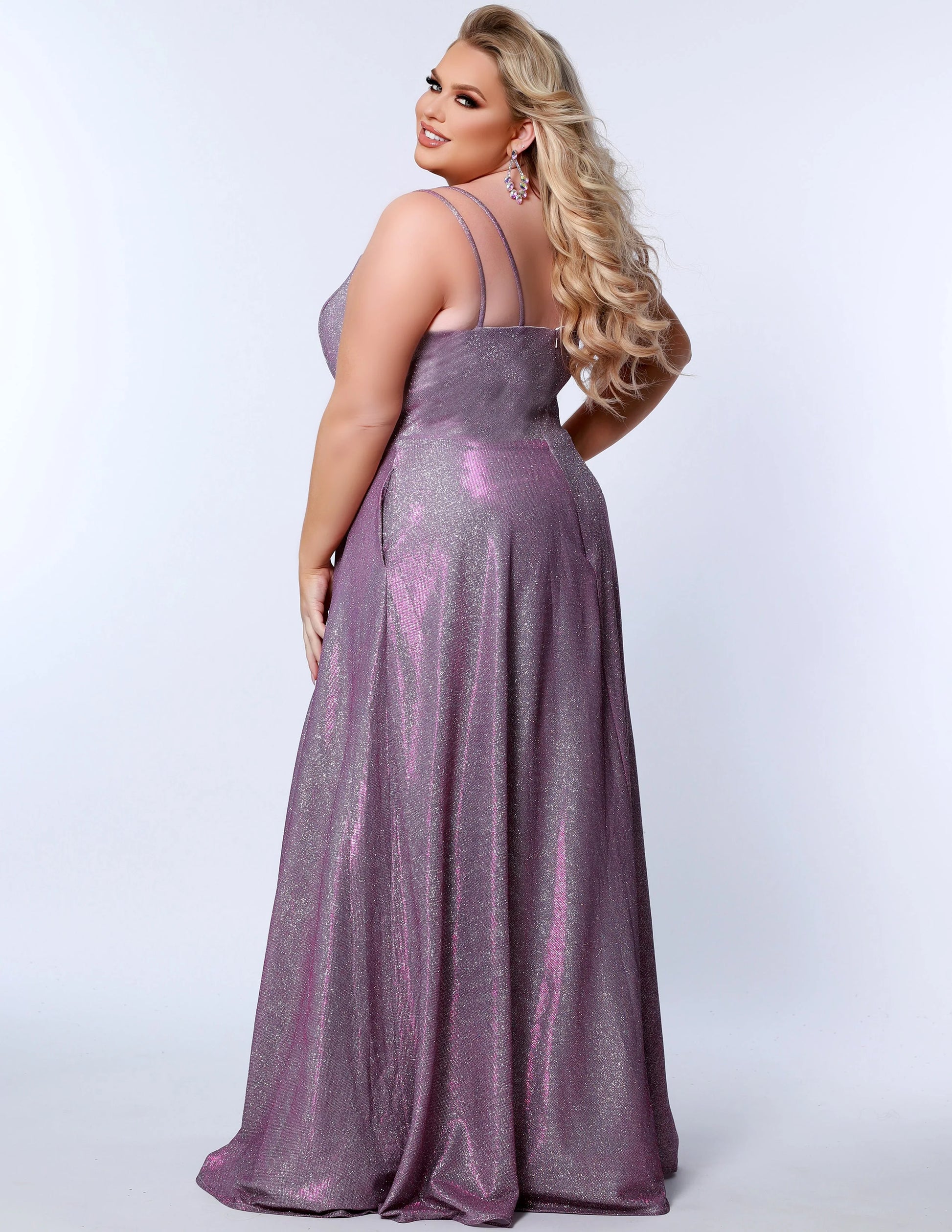 This plus-sized prom dress from Sydney's Closet SC7349 is made of shimmering knit and features an A-line silhouette, scoop neckline, double straps, zip-up back, natural waist, A-line skirt with slit, and hidden pockets. Fully lined for a comfortable and flattering fit. Perfect for special occasions. Keep it sweet and sparkly when you wear our classic A-line plus size prom dress! 