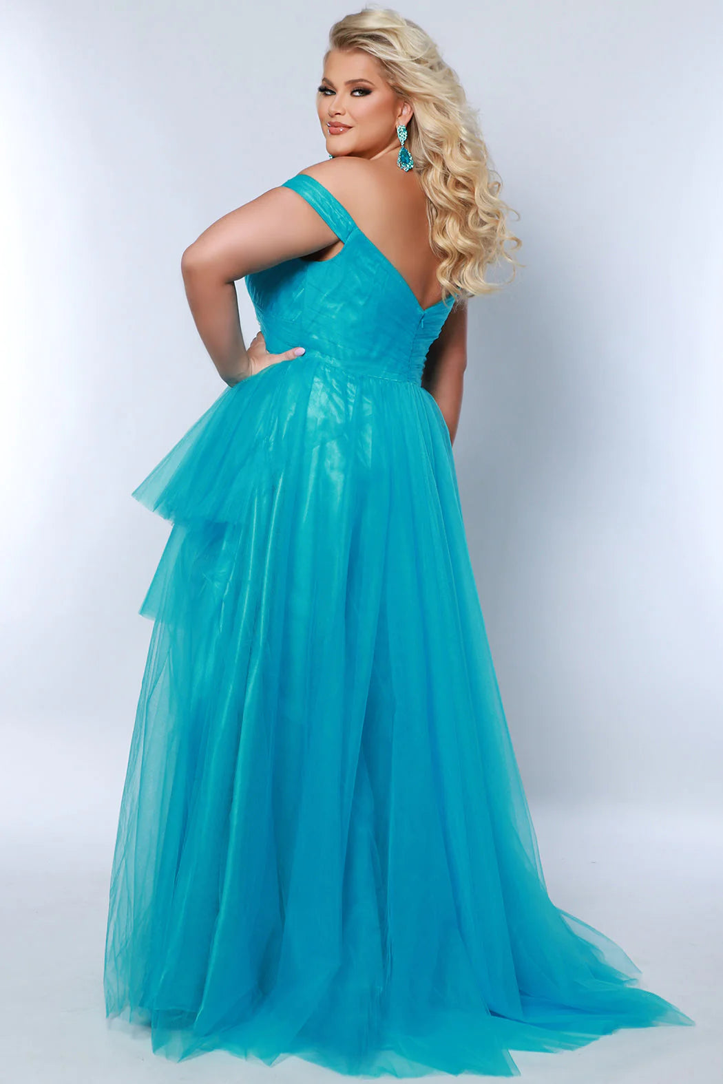 The Sydneys Closet SC7388 Long Prom Dress is a stylish A-Line design featuring an off-shoulder neckline and a 3-tier asymmetrical skirt. The plus size formal gown is a perfect choice for any pageant or other special occasion. Look fabulous no matter what your special occasion when you wear this showstopping  high-low formal dress in bold tulle fabric.