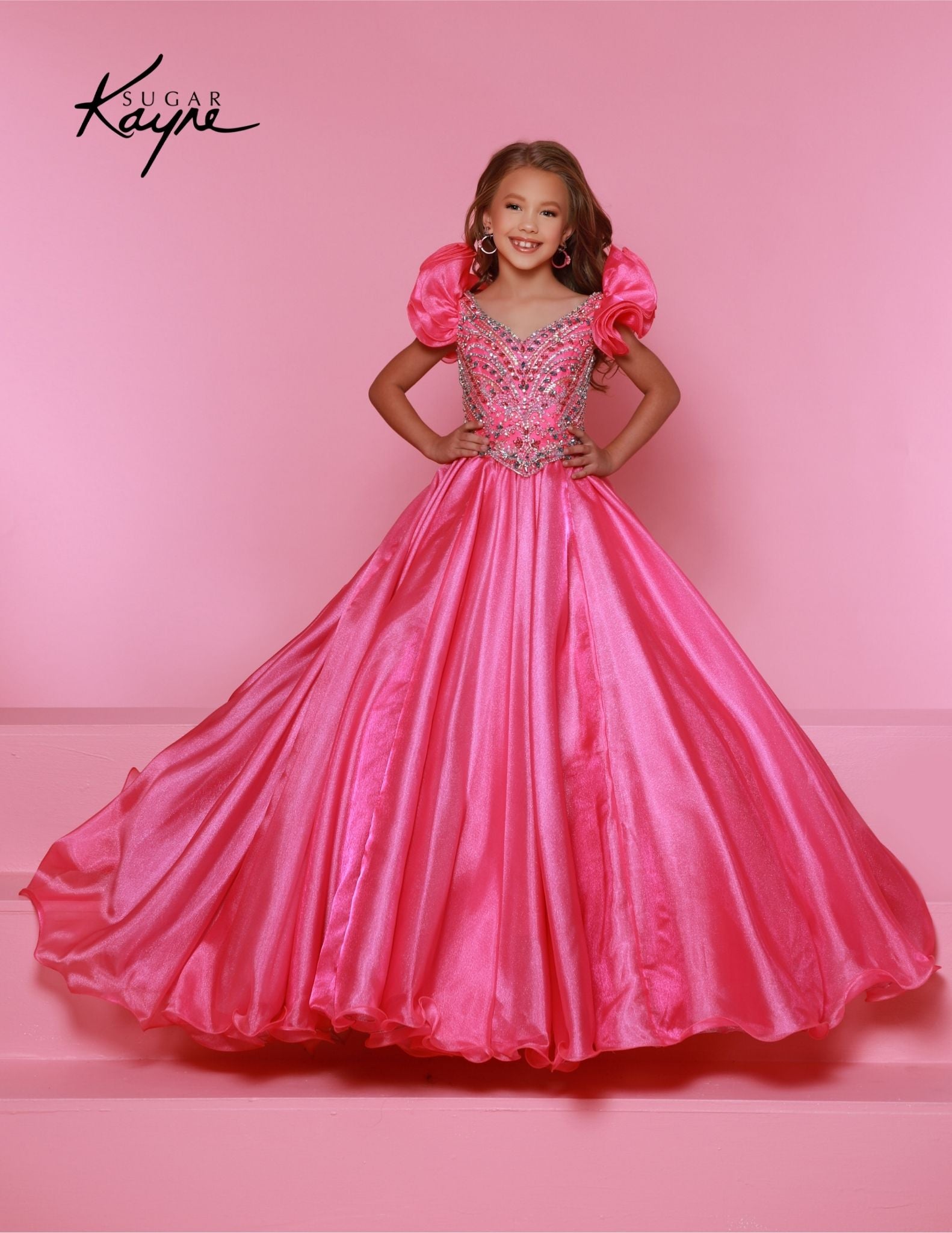 Bring out her inner beauty with this Sugar Kayne C334 Girls Pageant Dress. This luxurious dress is made from iridescent organza and features a sweetheart neckline and long ball gown skirt. Perfect for any special occasion. Transform into a twinkling starlet with this Metallic Organza Gown. The beaded bodice adds a touch of sparkle to this enchanting ensemble. The delicate ruffle sleeves create a charming look!