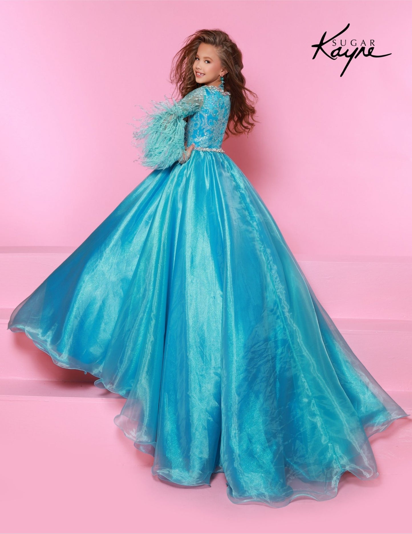 The Sugar Kayne C338 Preteen Pageant Dress is an elegant A-line ballgown featuring sequin and feather sleeves. Featuring the highest quality materials, this dress is perfect for special occasions and is sure to make your child feel like a princess. Experience twinkling elegance in this Metallic Organza Ballgown. The feathered sleeves are designed to make you feel like royalty.