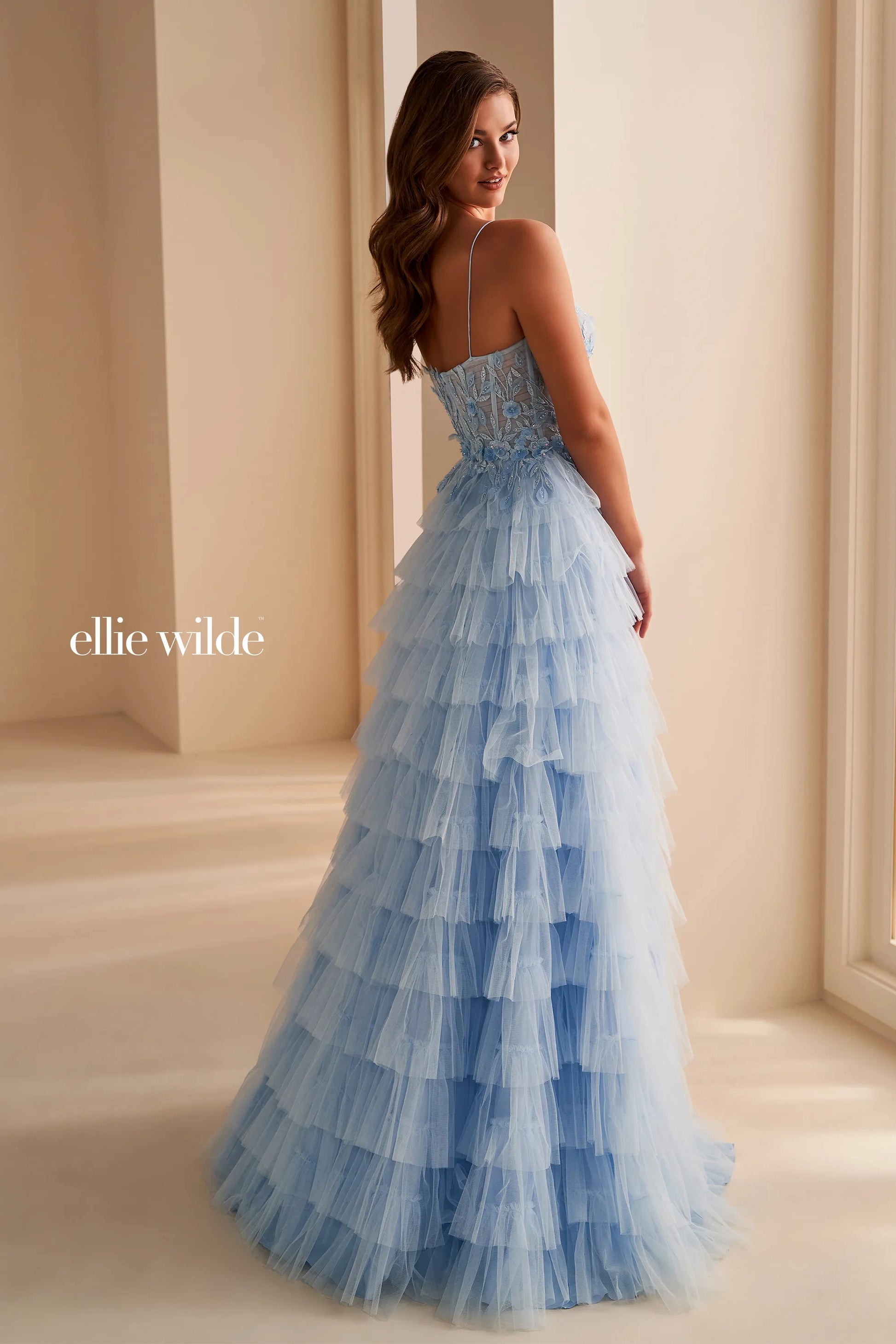 Elevate your prom night in this stunning Ellie Wilde EW36223 prom dress. The long tulle layers create a flowing silhouette, while the sheer lace corset adds a touch of delicate beauty. Complete with a dramatic maxi slit, this formal gown is perfect for making a lasting impression.