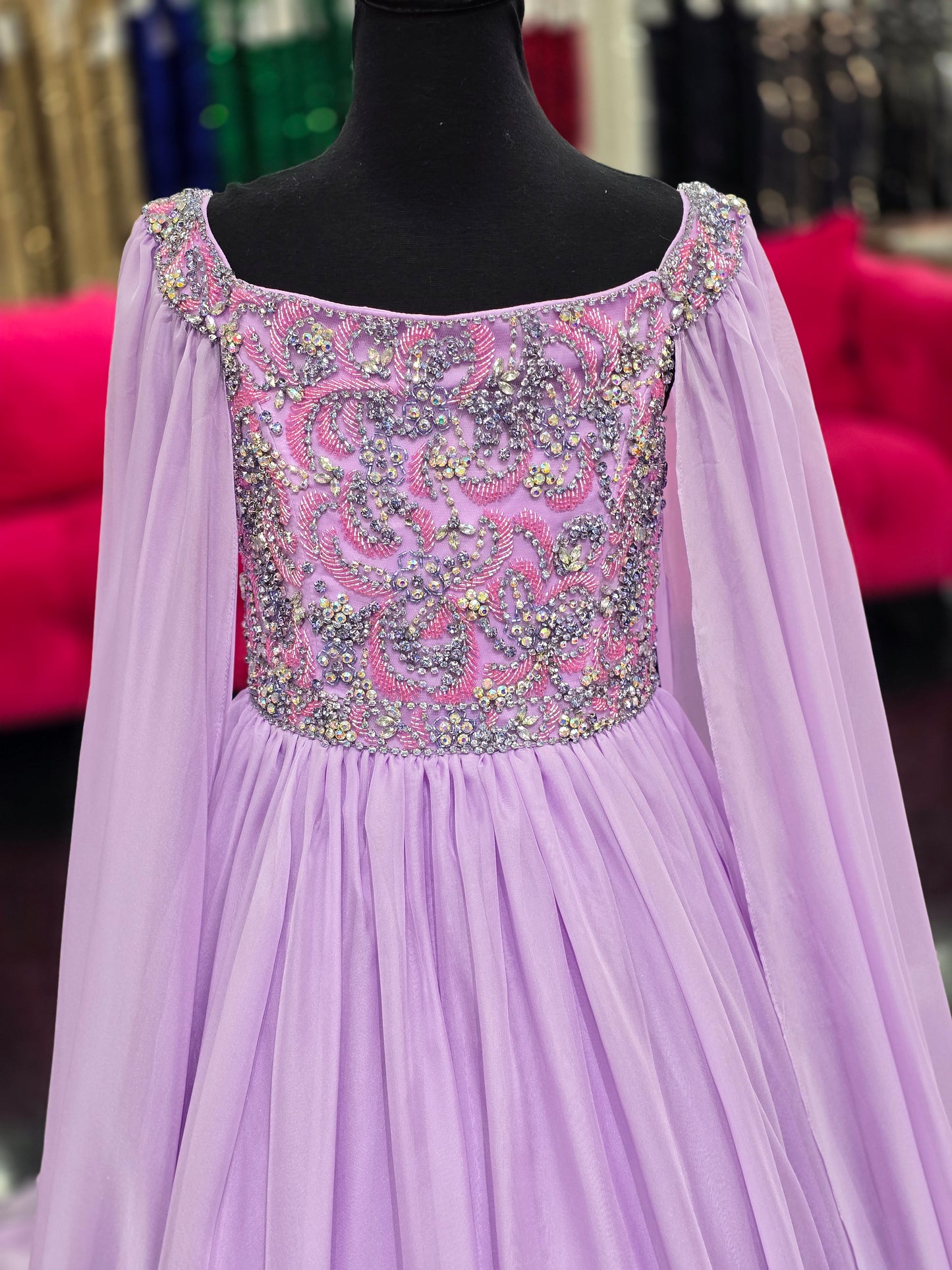 The Samantha Blade 1022 Girls Pageant Dress is the perfect choice for your little one's big day. With a stunning beaded crystal bodice and off-the-shoulder cape sleeves, she'll shine like a star. The chiffon ballgown train adds a touch of elegance and ensures she'll make a grand entrance.