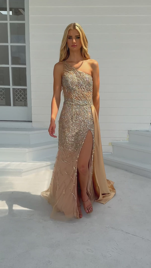 Expertly crafted for the ultimate prom or pageant look, the Ava Presley 28589 Long Prom Dress features a stunning one shoulder design, intricate beaded crystal detailing, and a sheer bodice for a touch of elegance. With a sleek side satin skirt and a high slit, this formal gown exudes sophistication and style.