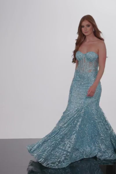 The Jovani 22601 is a captivating prom dress designed for the formal collection, perfect for making a grand entrance at your special event. It's crafted from delicate tulle, which lends an ethereal quality to the gown. This dress showcases a striking mermaid style, designed to hug your curves and create a dramatic, flared bottom for an elegant and show-stopping effect. The gown is adorned with a glittering design, adding a touch of sparkle and sophistication to your look. 