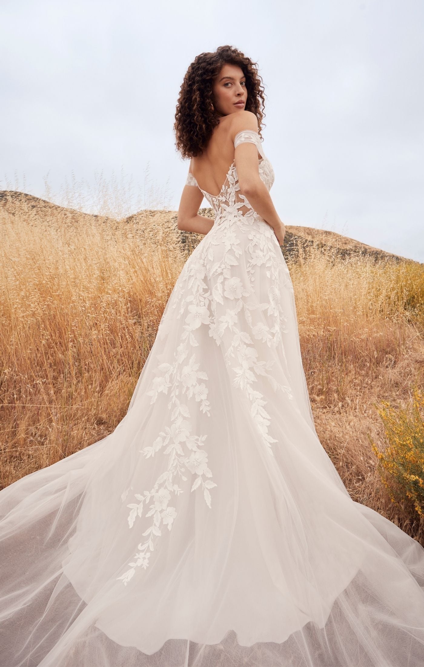 Casablanca Beloved BL433 A-Line Floral Lace Deep V-Neck Off The Shoulder Tulle Train Wedding Gown. Penny’s A-line silhouette defines her feminine form, perfectly subtle yet flattering on any size and shape. A symphony of floral lace appliques flow from her bodice, trailing down into her flattering A-line skirt