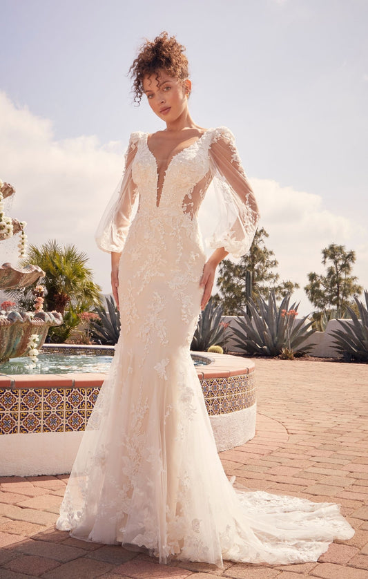 Casablanca Beloved BL434 Mermaid Sheer Long Sleeve V-Neck Open Back Lace Floral Tulle Train Wedding Gown. Undeniably feminine, Montie is the perfect mix between romantic floral lace motifs and figure flattering silhouettes. Perfect for the outgoing yet romantic bride, Montie’s plunging V neckline and curve sculpt lining bodice is contrasted with delicate feminine floral beaded & sequined lace, met with illusion balloon sleeves.