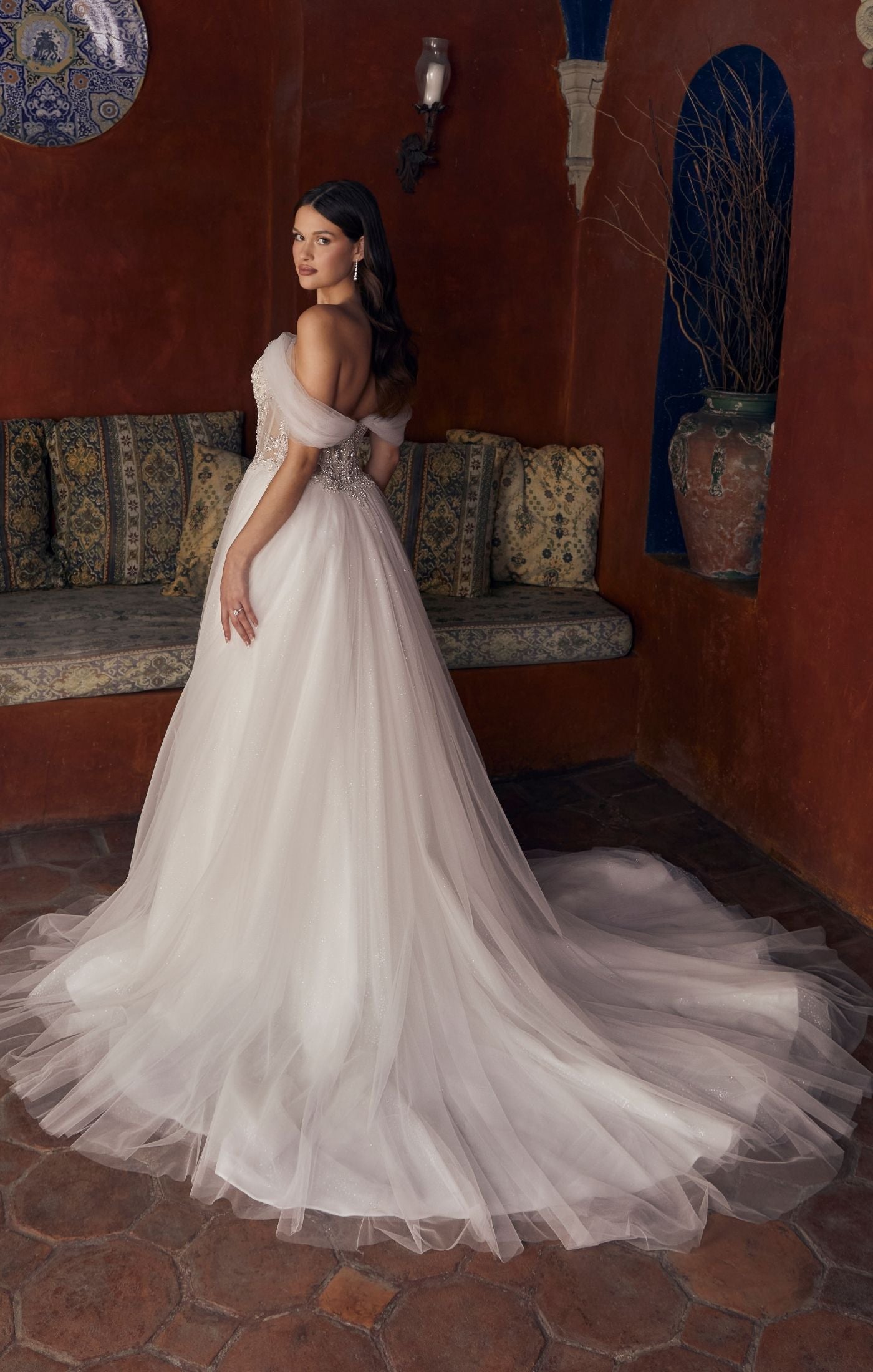 Casablanca Bridal 2547 Meline A-Line Ballgown Sheer Corset Off The Shoulder Plunging Neckline Train Wedding Gown. 2547 is a sparkling sensation, for the bride who wants to glimmer from every angle. This stunning ballgown wedding dress features an intricately beaded illusion bodice, accented by a plunging neckline and detachable off the shoulder, soft tulle straps. From tulle off-shoulder straps, to completely strapless, this versatile gown offers options for a reception change!