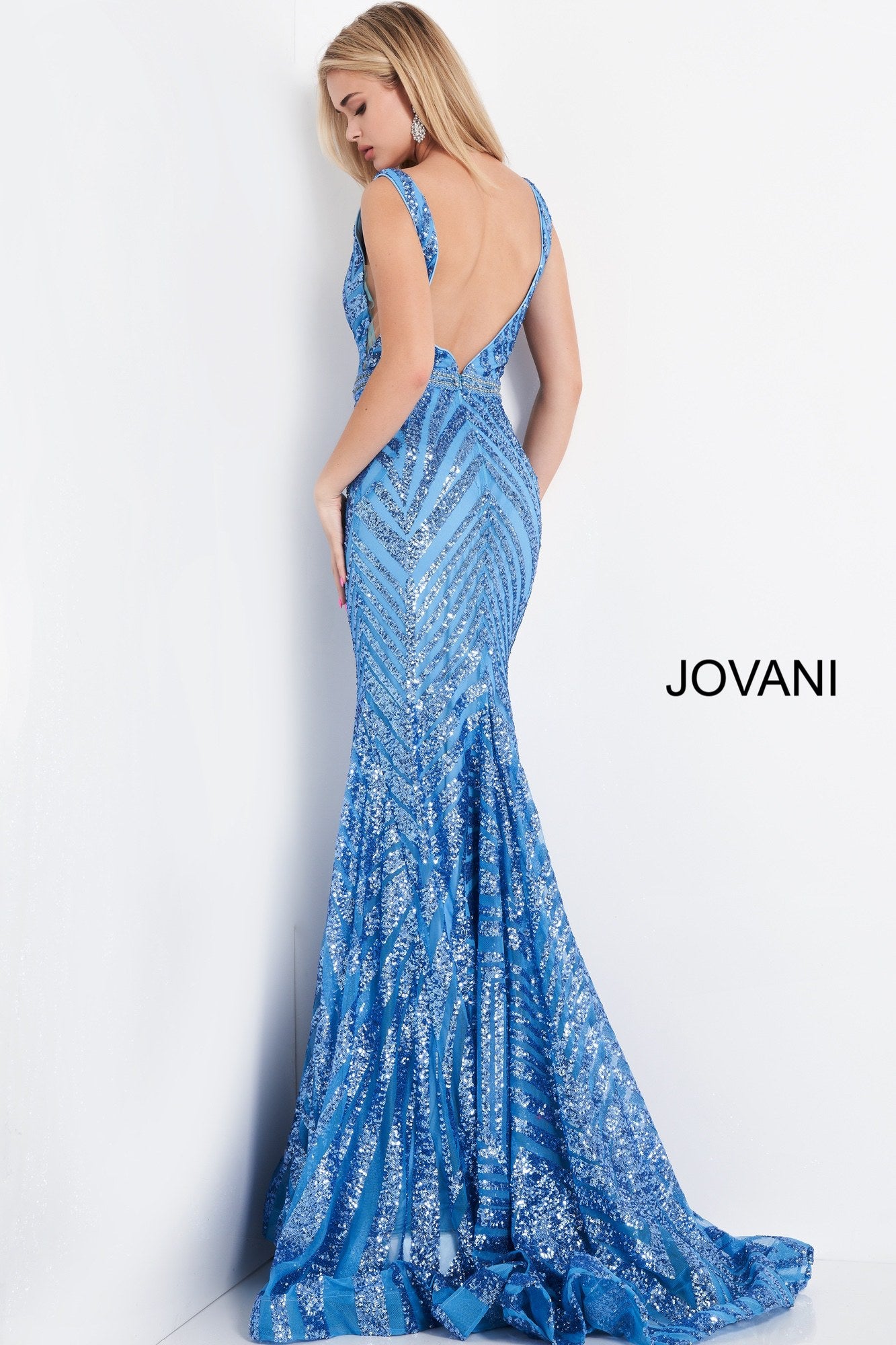 Jovani 03570 is a Long fitted formal evening gown. Featuring a fully Embellished geometric sequin pattern. Plunging deep V Neckline and open V back. This Backless Pageant Gown Features a mermaid silhouette with a lush trumpet skirt & Sweeping train. Sheer side panels with mesh insert. Crystal Rhinestone embellished waist belt. Available Sizes: 00,0,2,4,6,8,10,12,14,16,18,20,22,24  Available Colors: black/nude, light-blue, red, rose/gold, yellow