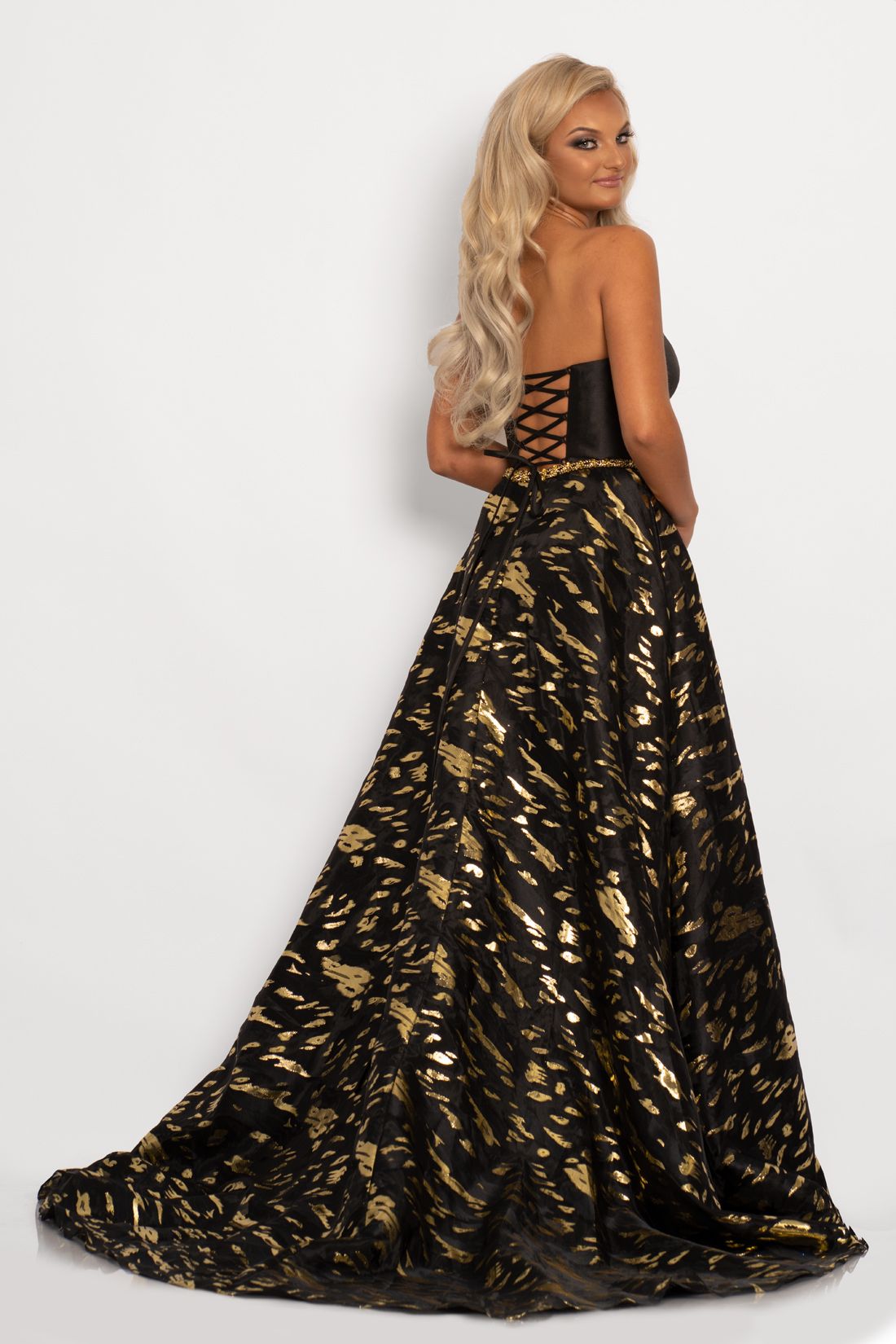 Johnathan Kayne 2232 This unique prom dress has a modified sweetheart neckline on a strapless design top with an open lace up tie corset in the back.  The print A line skirt on this evening gown is made of metallic organza burnout with a side slit Colors  Black/Gold, White/Multi  Sizes  00, 0, 2, 4, 6, 8, 10, 12, 14, 16