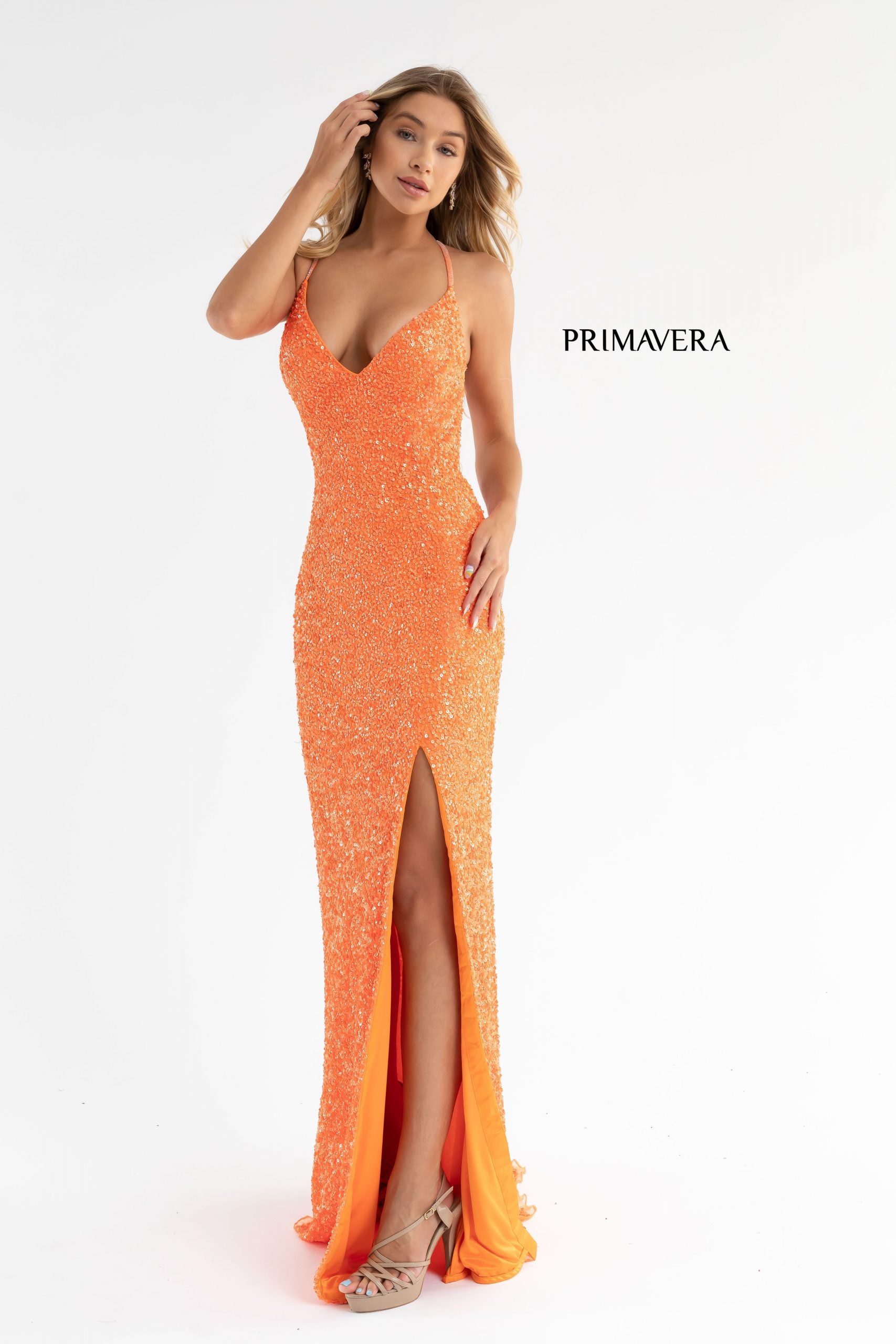 Primavera Couture 3291 Exclusive Prom Dresses.  This long prom dress is embellished throughout with shimmering sequins.  This impressive gown showcases a v neckline, thin beaded straps and crisscrossed straps in the open back. The long slim skirt has a sultry high side front slit. 