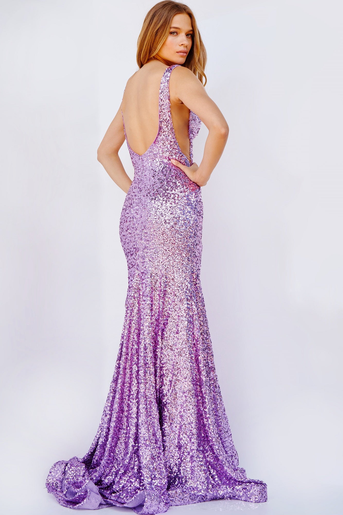 Jovani 23079 This long fit and flare prom dress is adorned with shimmering sequins, a plunging V neckline, and finished with an elegant horsehair trim and sweeping train.  Available colors:  Lilac, Emerald, Turquoise, Gold