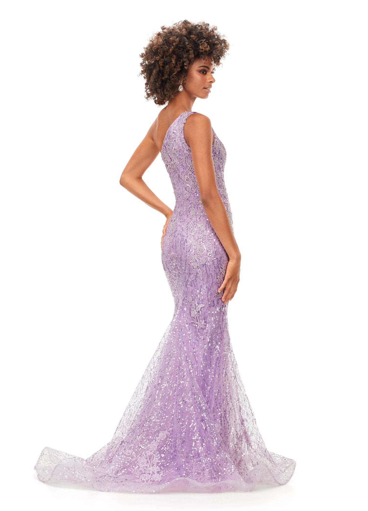 Ashley Lauren 11334 Feel ultra glamourous in this one shouldersequin gown. The bodice is embellished with lace appliques that cascade down onto the fitted skirt. The look is complete with a full zipper back. One Shoulder Fitted Skirt Sequin Applique Sweep Train COLORS: Sky, Lilac